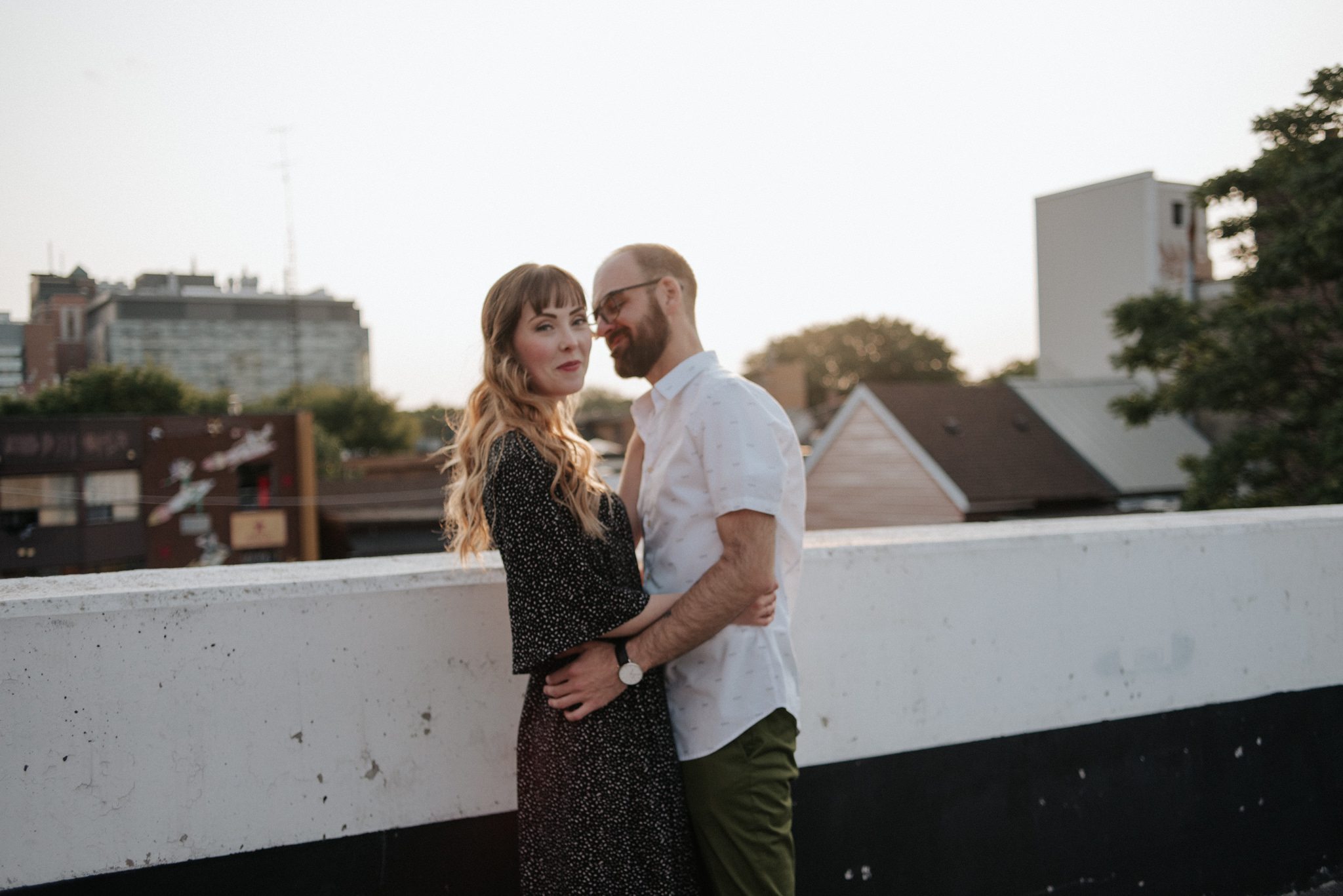 Couple hugging on rooftop in Toronto at sunset