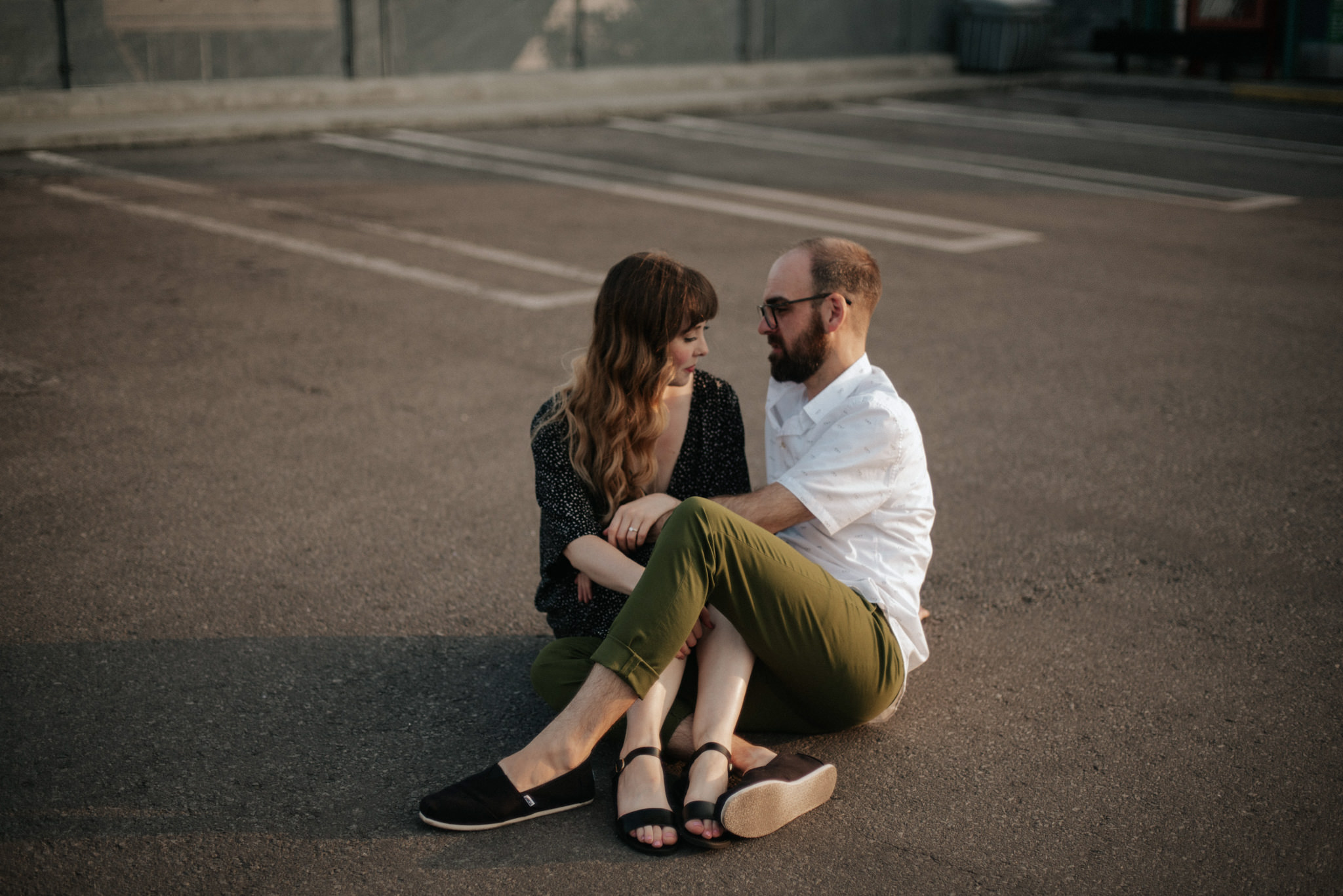 Couple sitting on ground on rooftop in Toronto at sunset