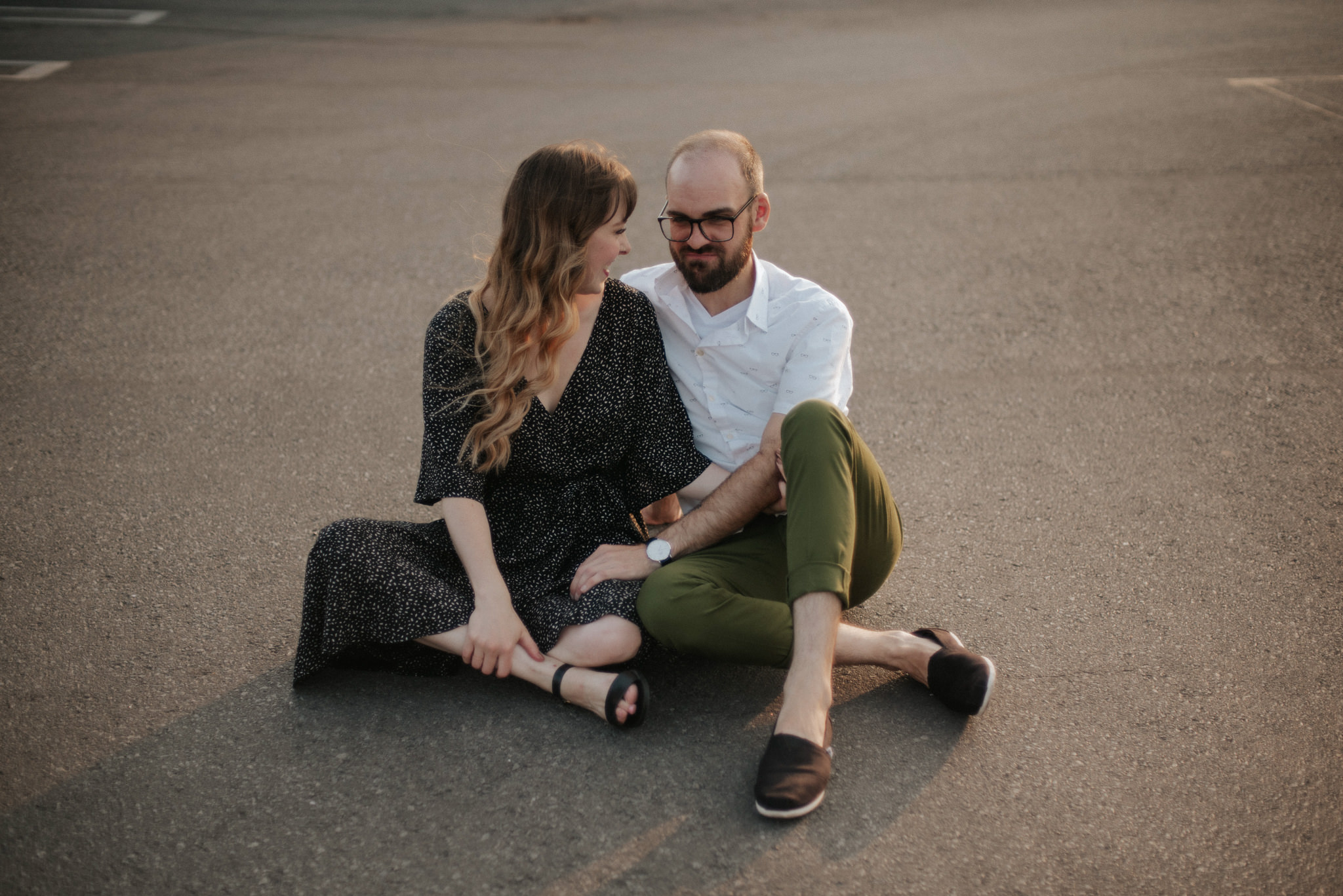 Couple sitting on ground on rooftop in Toronto at sunset