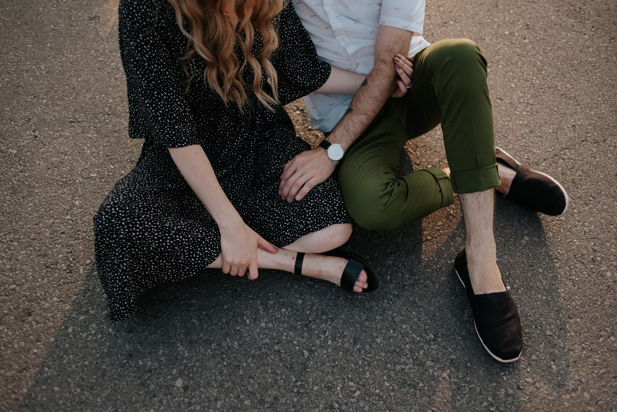 Couple sitting on ground on rooftop in Toronto at sunset