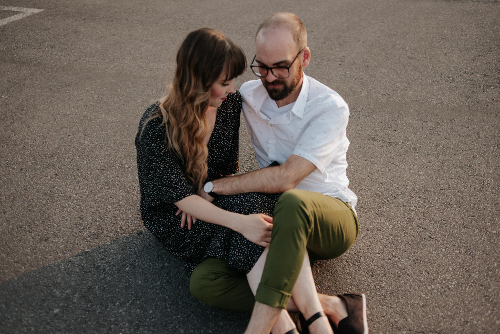 Couple sitting on ground on rooftop in Toronto at sunset