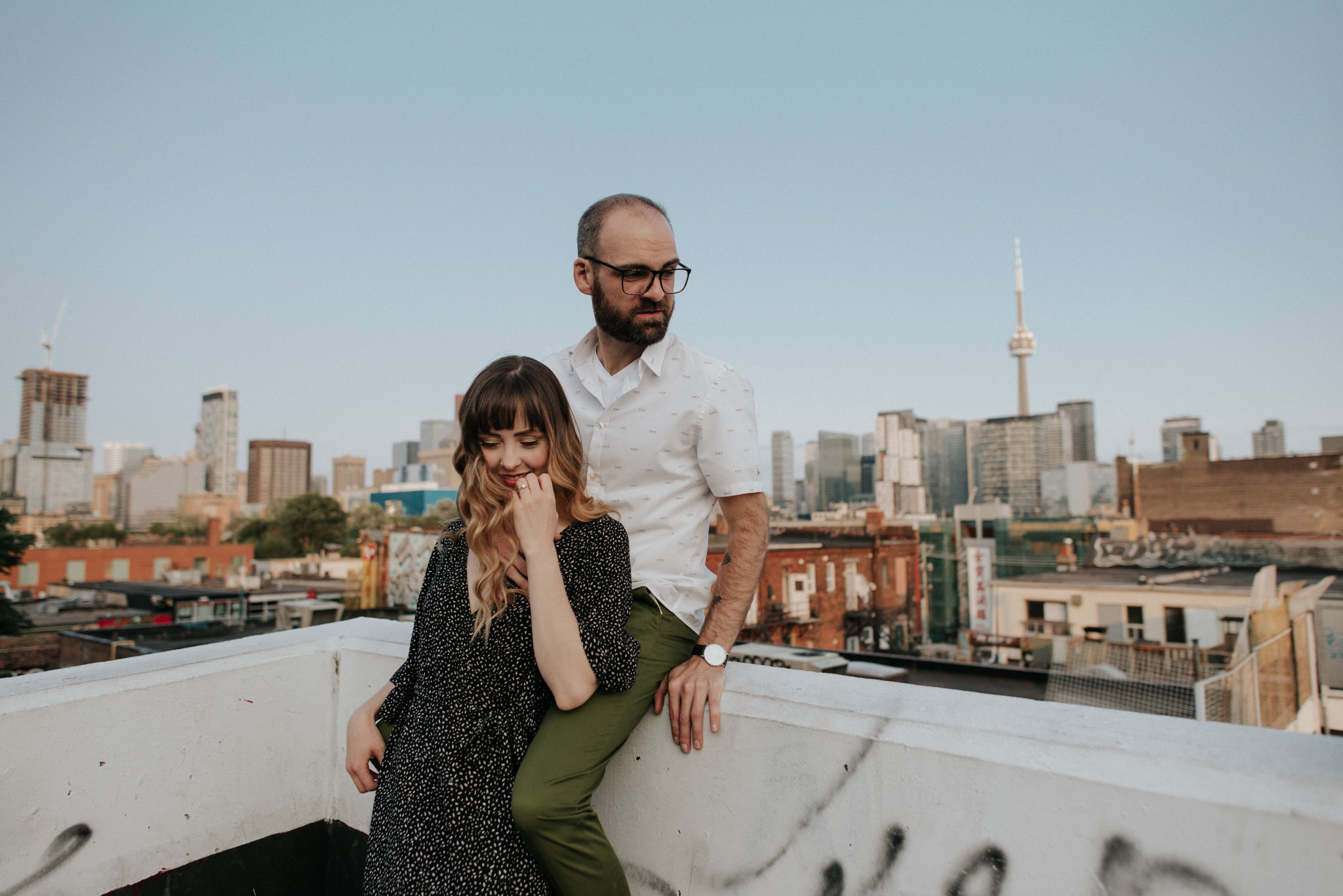 Couple on rooftop with Toronto skyline in background at sunset