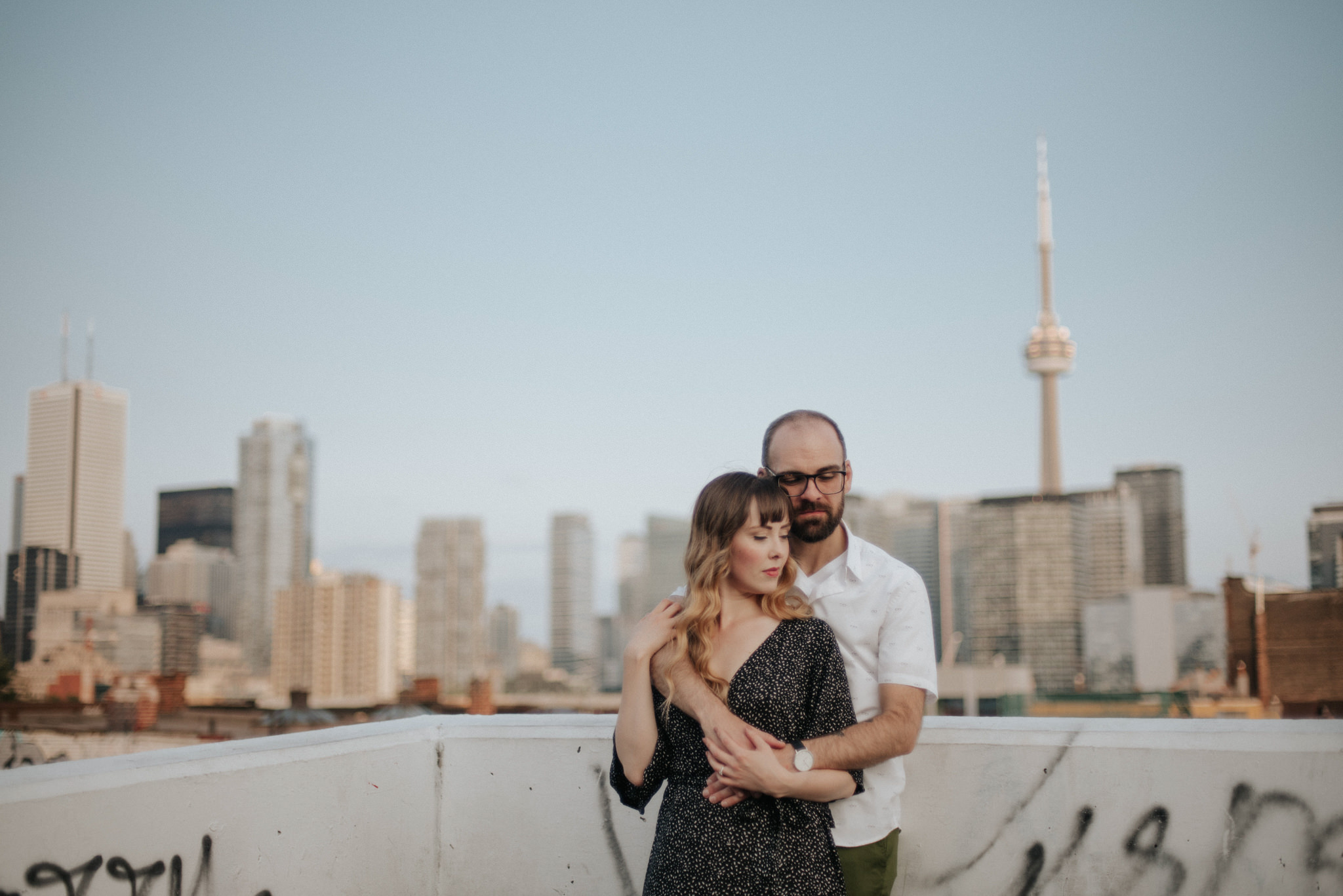 Couple on rooftop with Toronto skyline in background at sunset