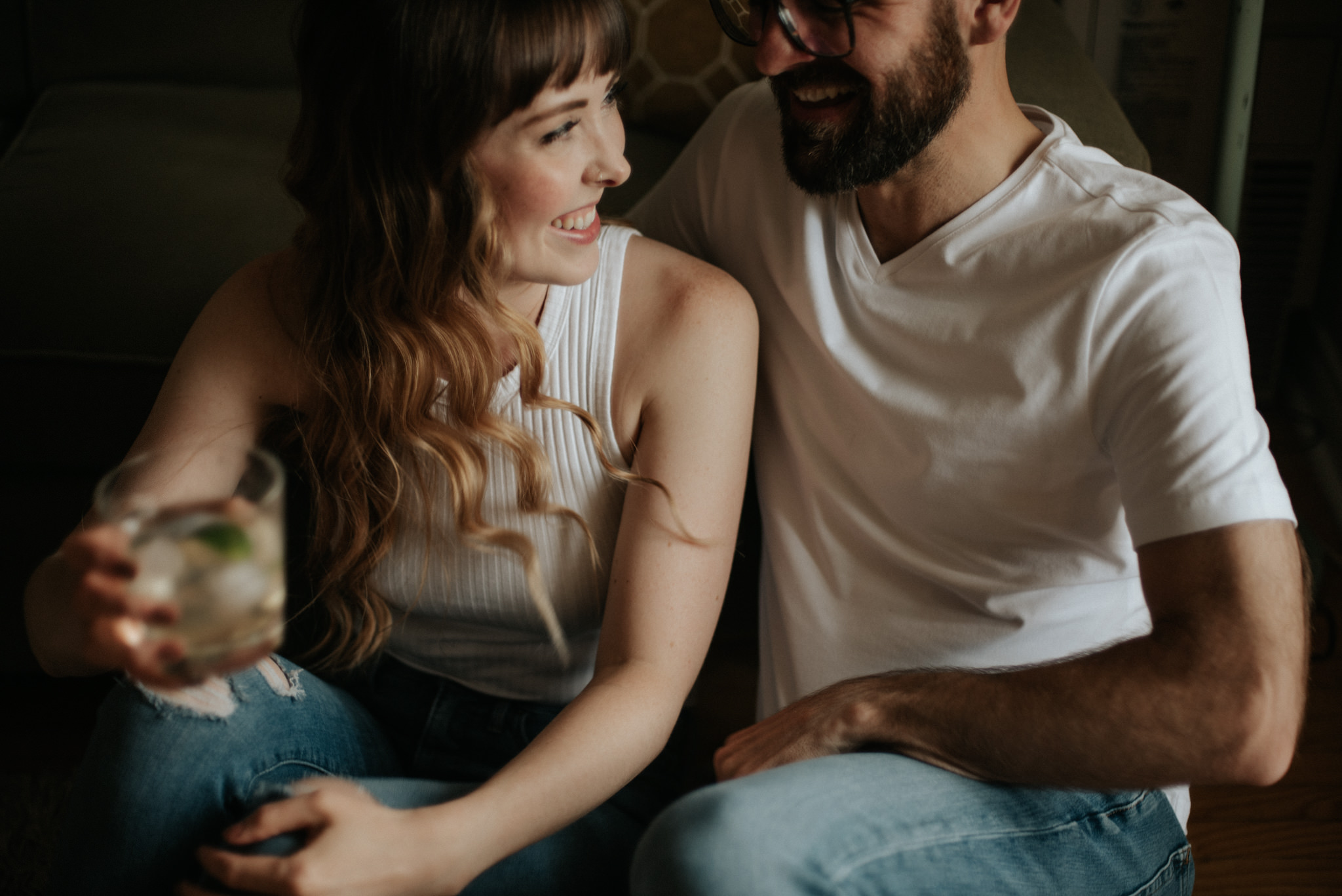 Couple laughing and sitting on apartment floor