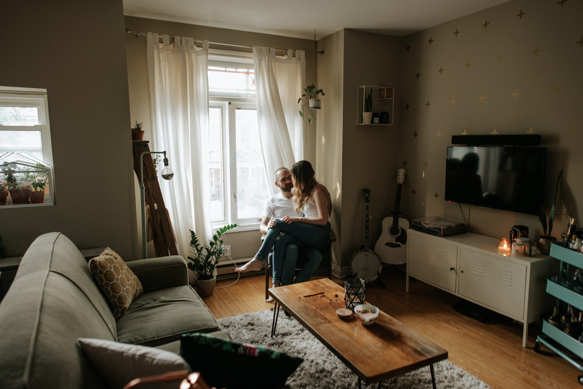 Couple cuddling on chair in apartment living room in Toronto