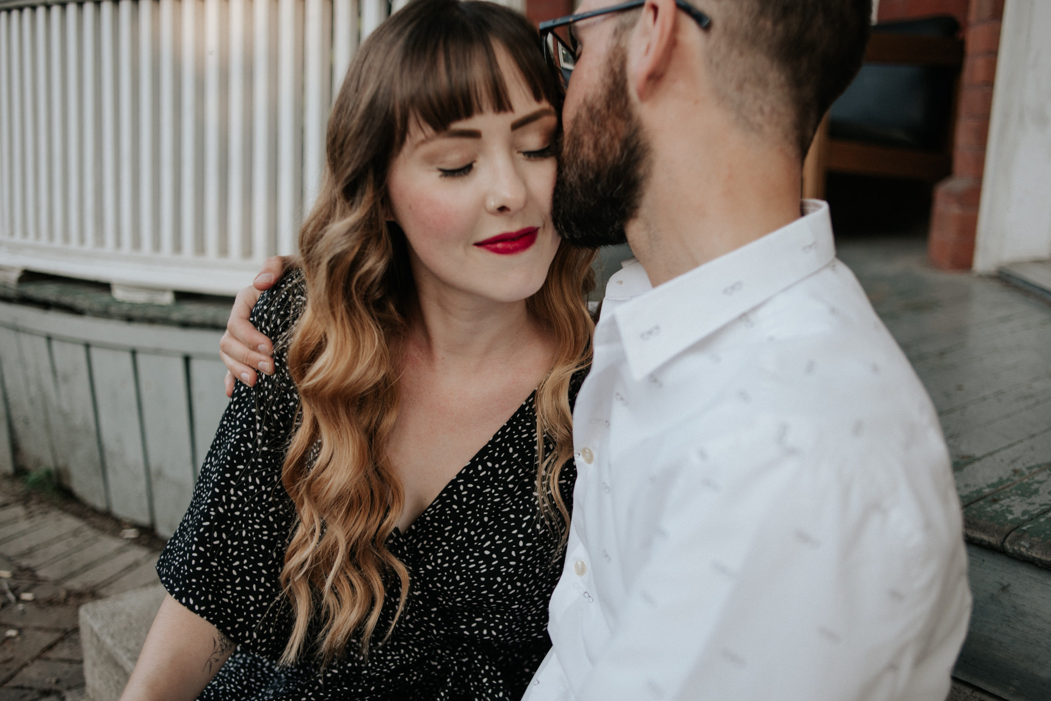 Couple sitting on front porch steps hugging