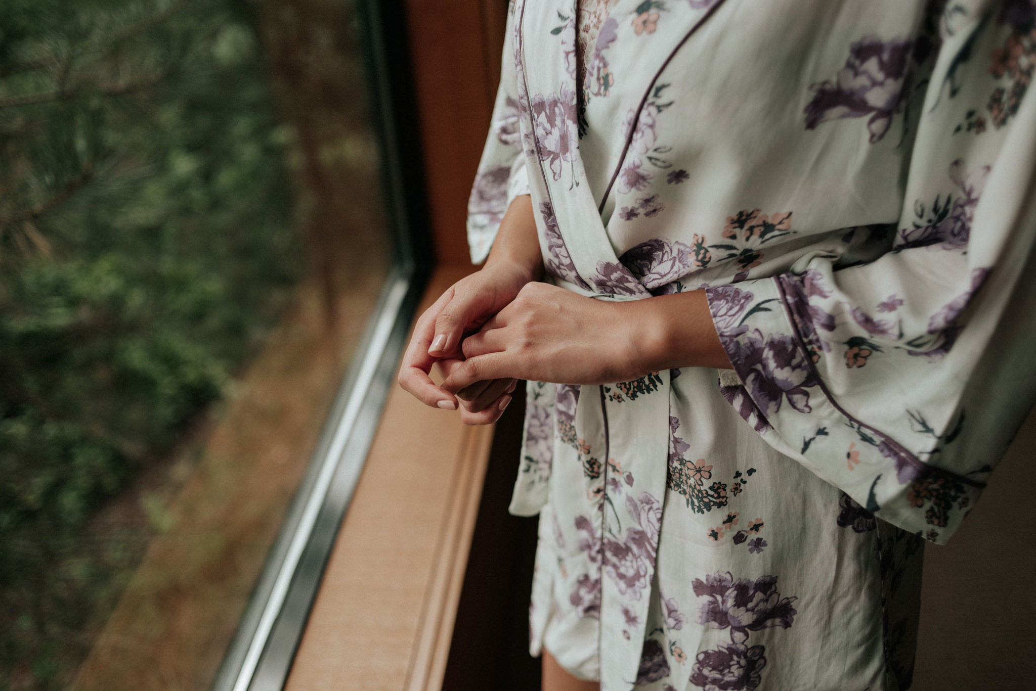 bride getting ready by window at Wickaninnish Inn for her Tofino Elopement