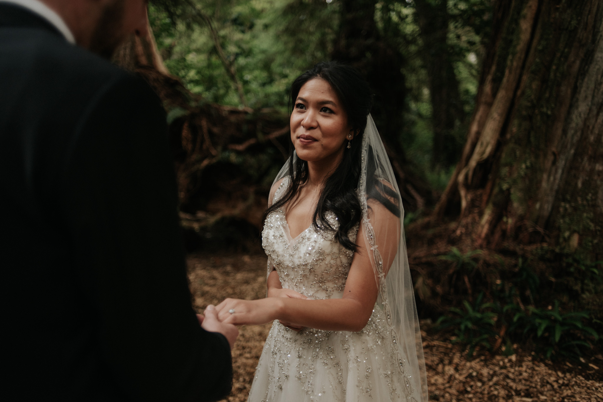 bride and groom holding wedding rings in hands