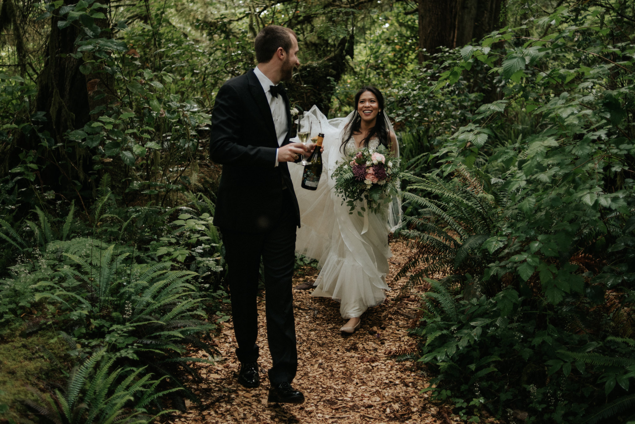 bride and groom drinking champagne after wedding ceremony in forest in Tofino