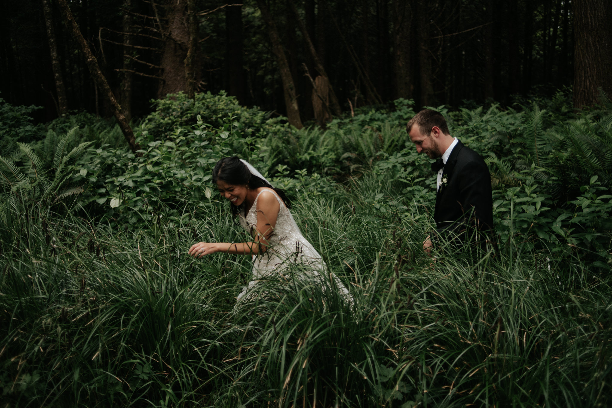 Couple standing in sea grass in forest in Tofino