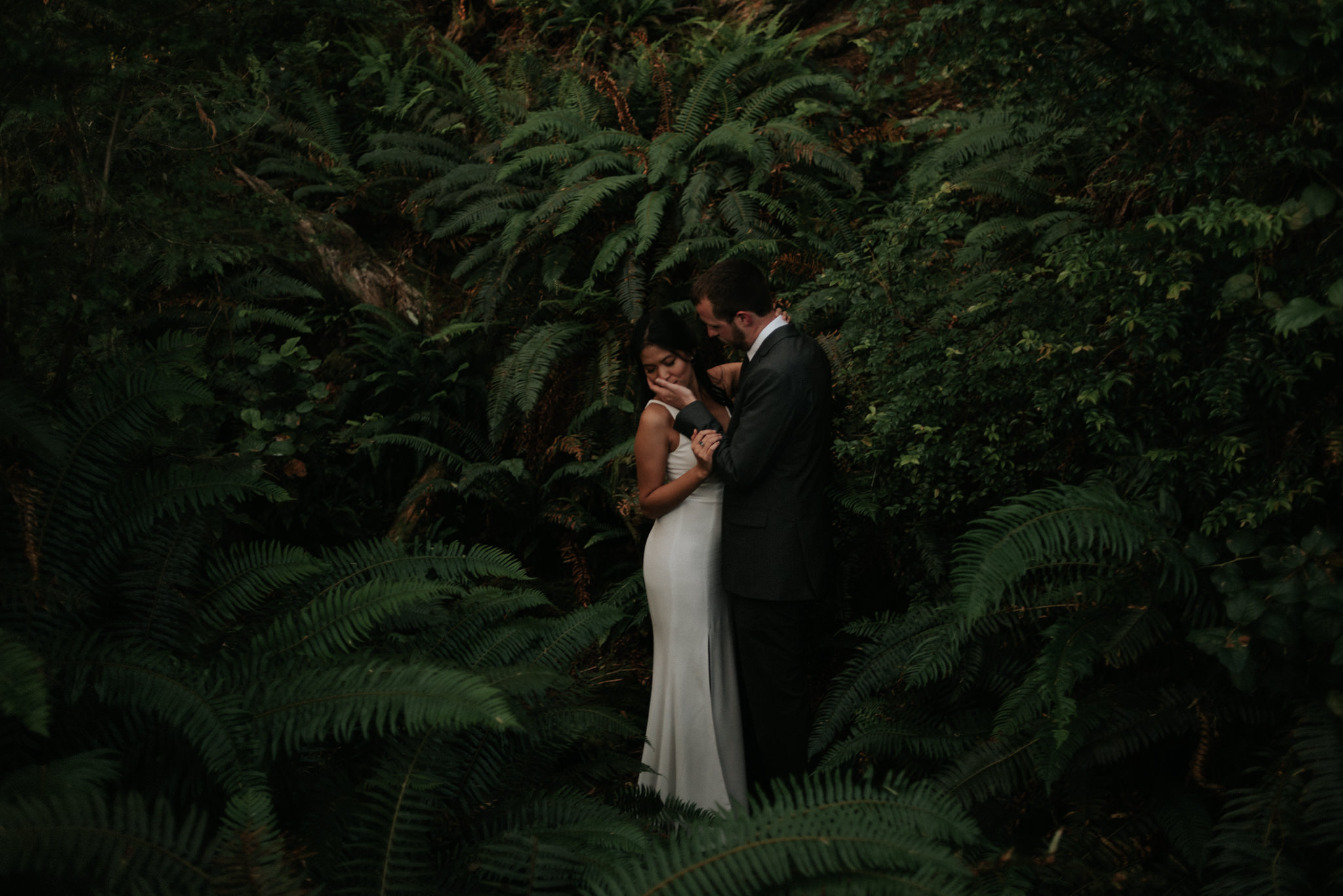 couple standing in ferns on wedding day