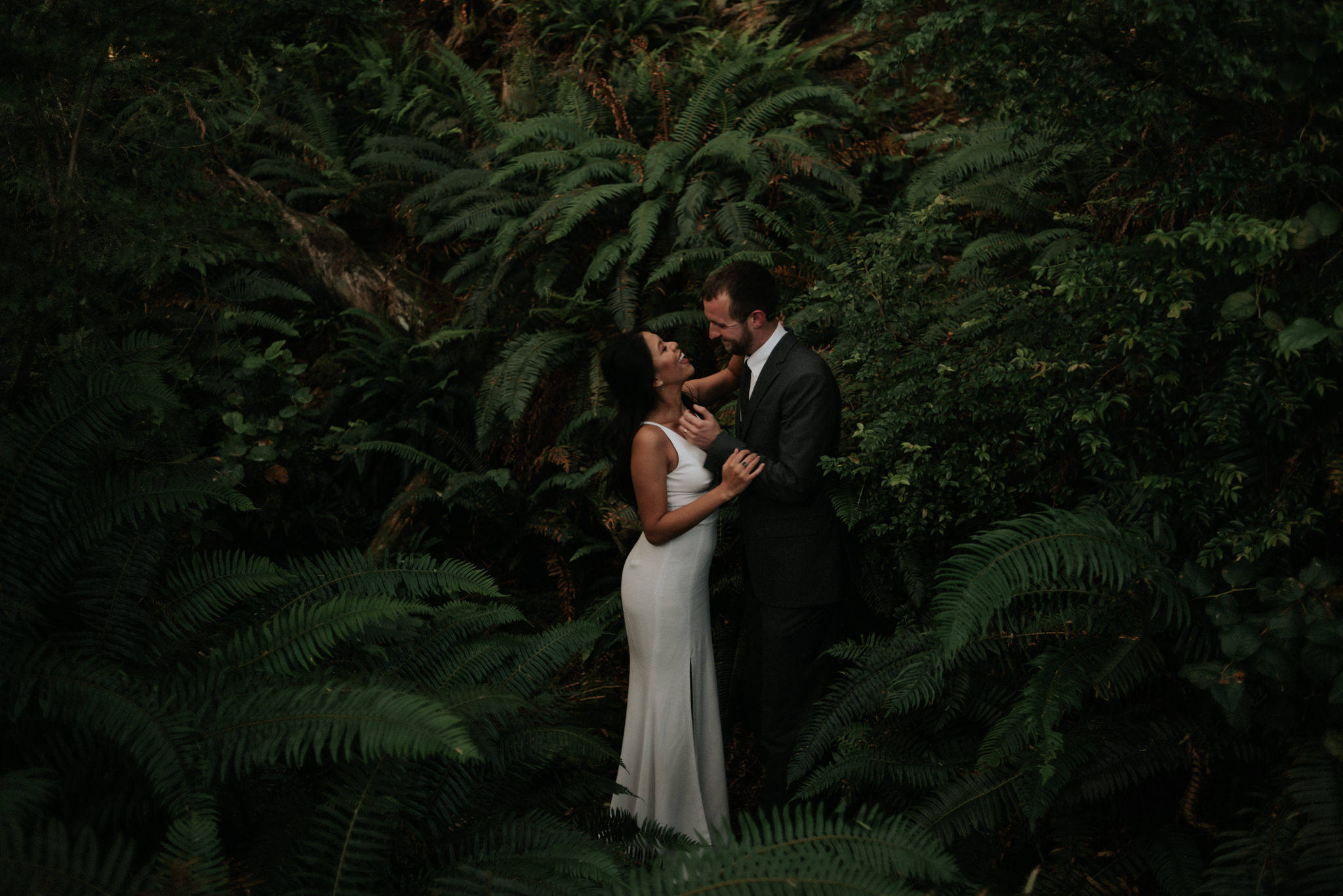 bride and groom holding hands in forest in Tofino