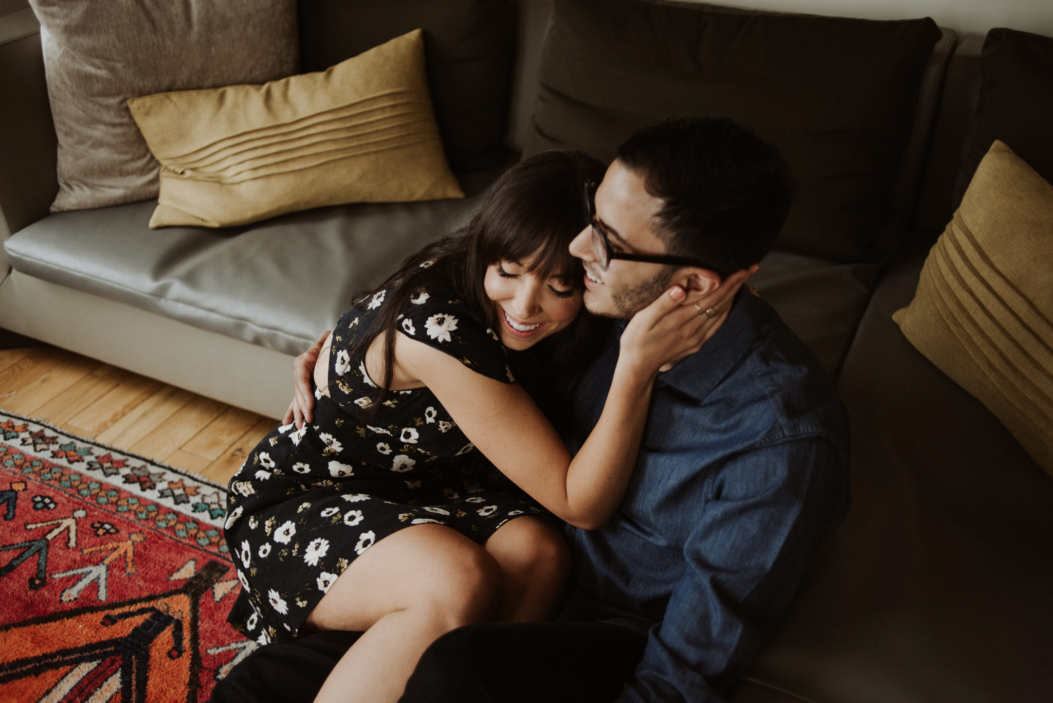 couple cuddling and laughing on living room floor