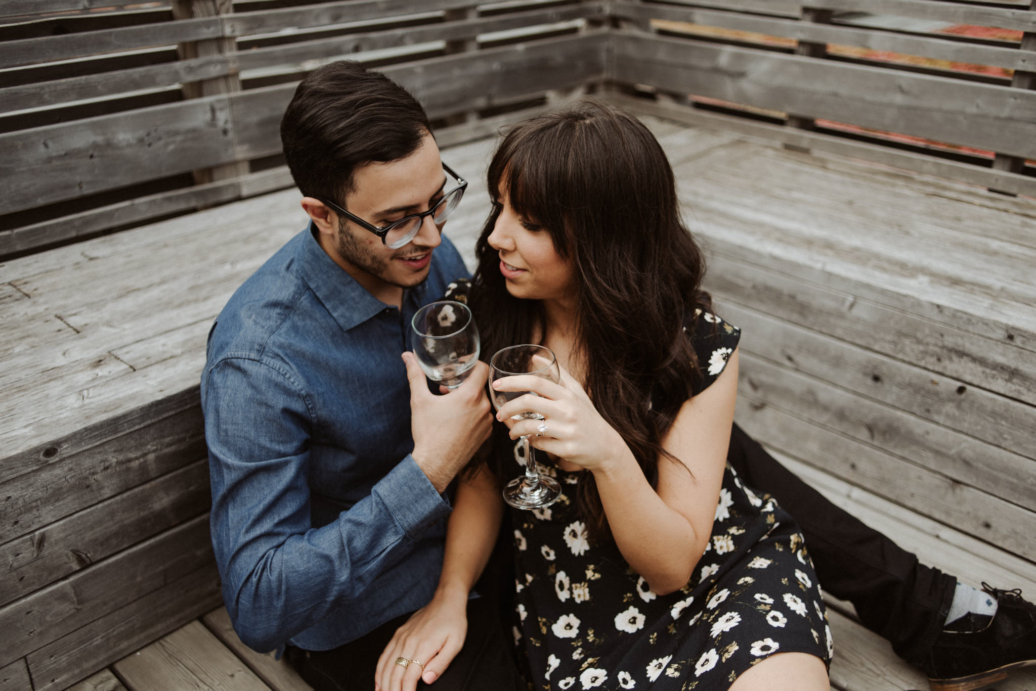 couple cuddling on rooftop and drinking wine