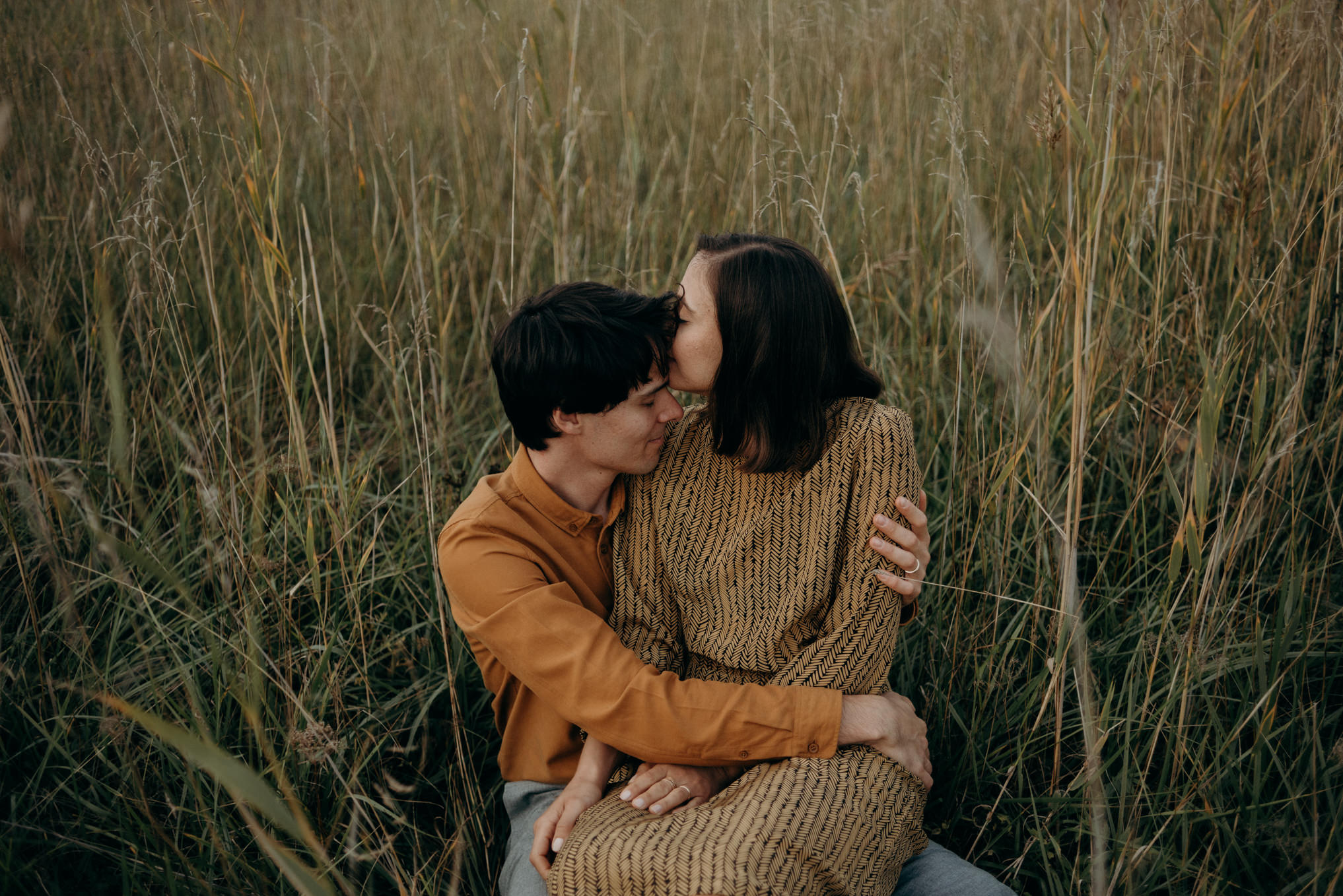 couple in love sitting in tall grass