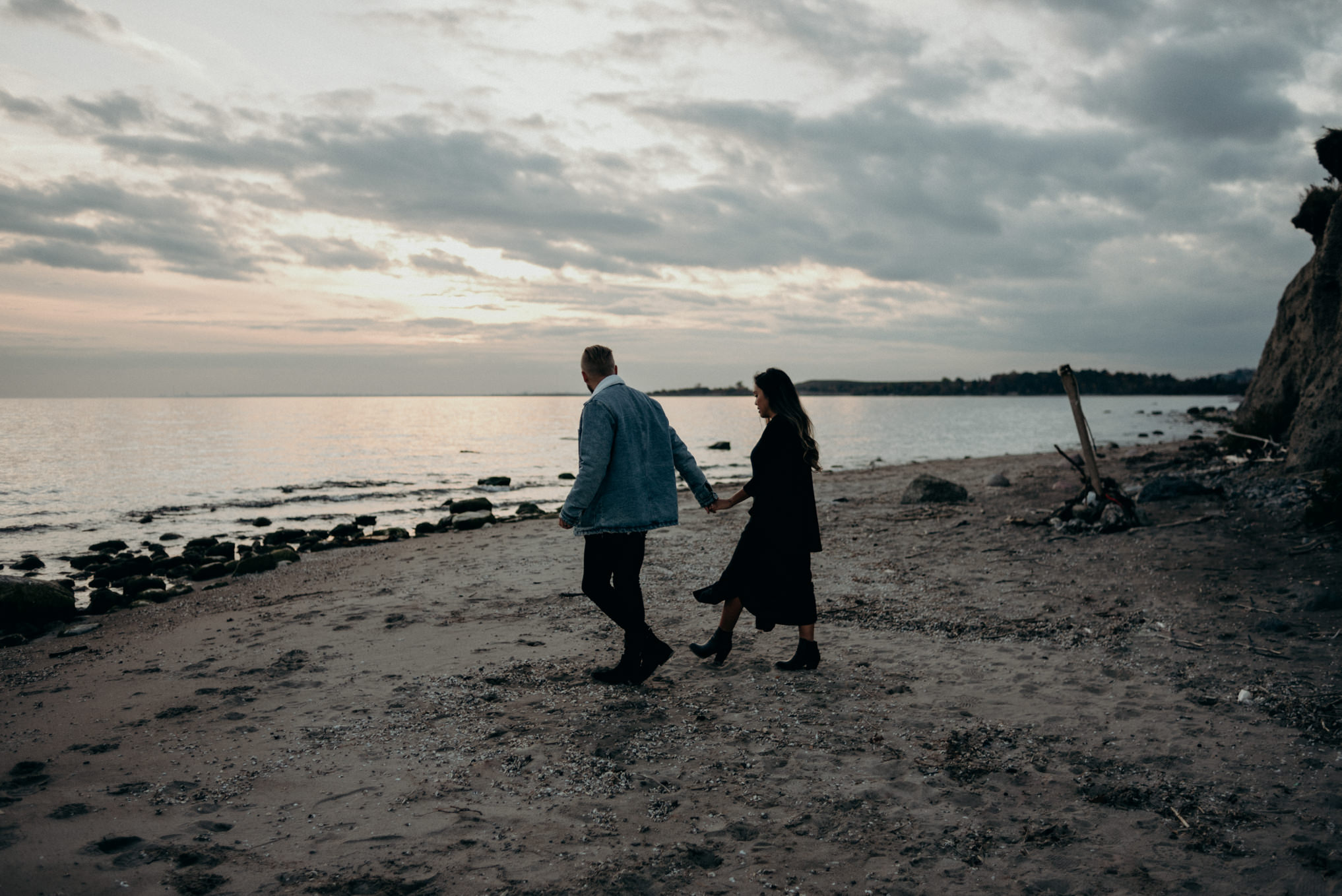 couple interracial couple walking and holding hands on beach at sunset