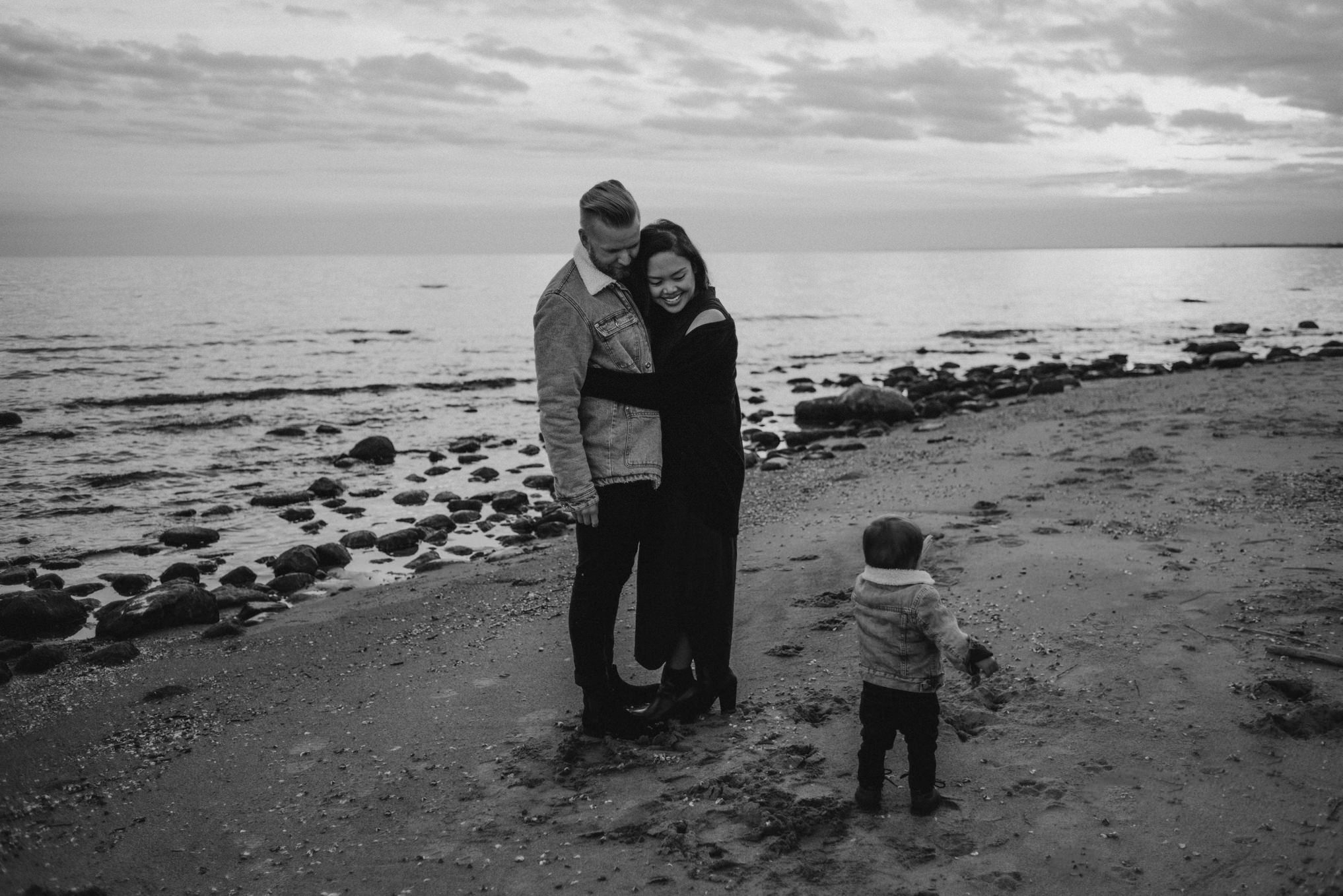 Hip Toronto couple standing on beach at Lake Ontario at sunset