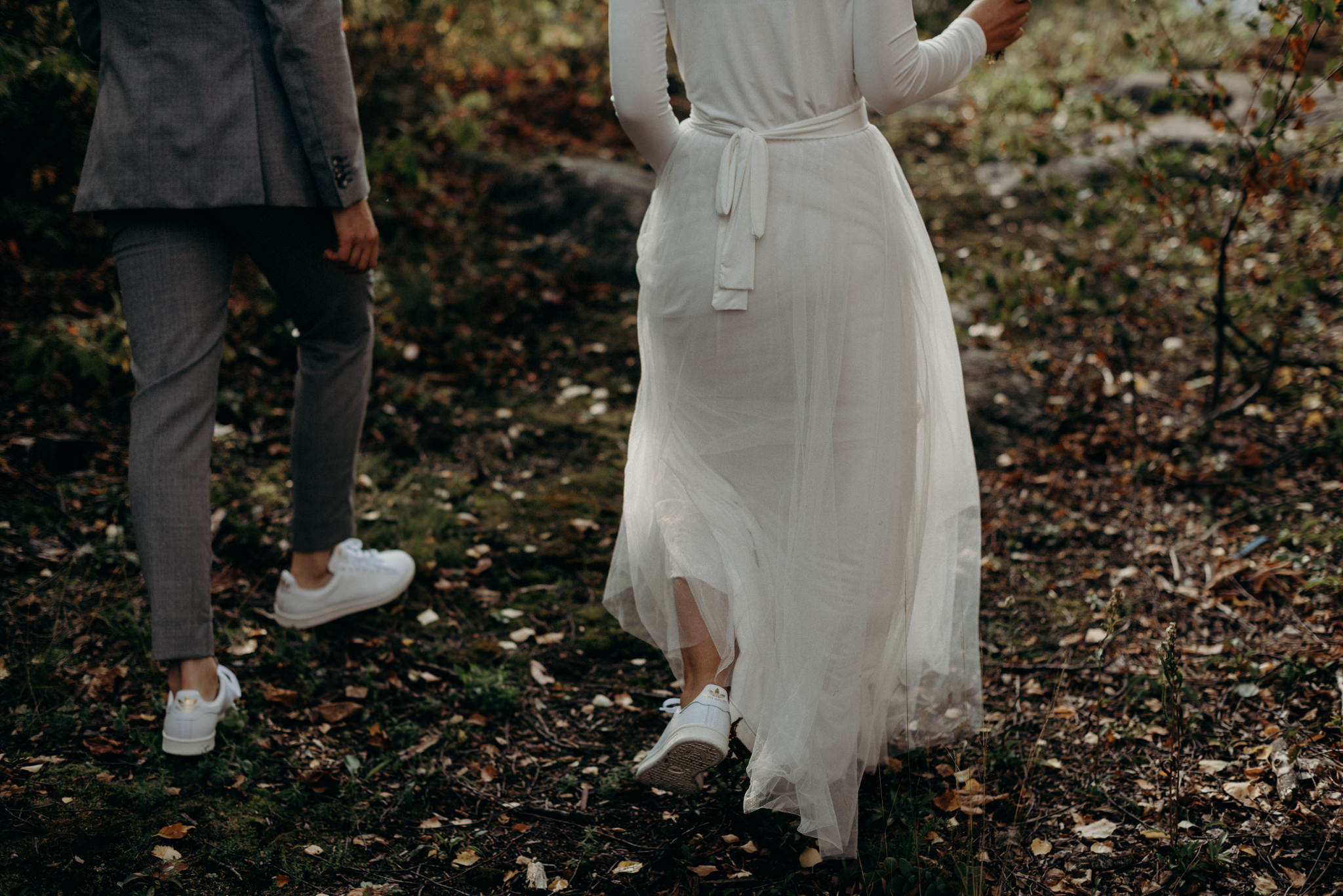 bride and groom standing on hill surrounded by trees on island near Helsinki