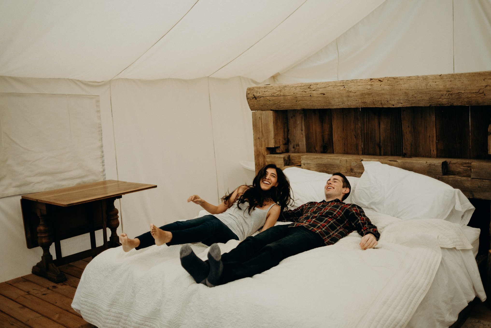 Couple lying on bed in glamping tent at Whispering Springs