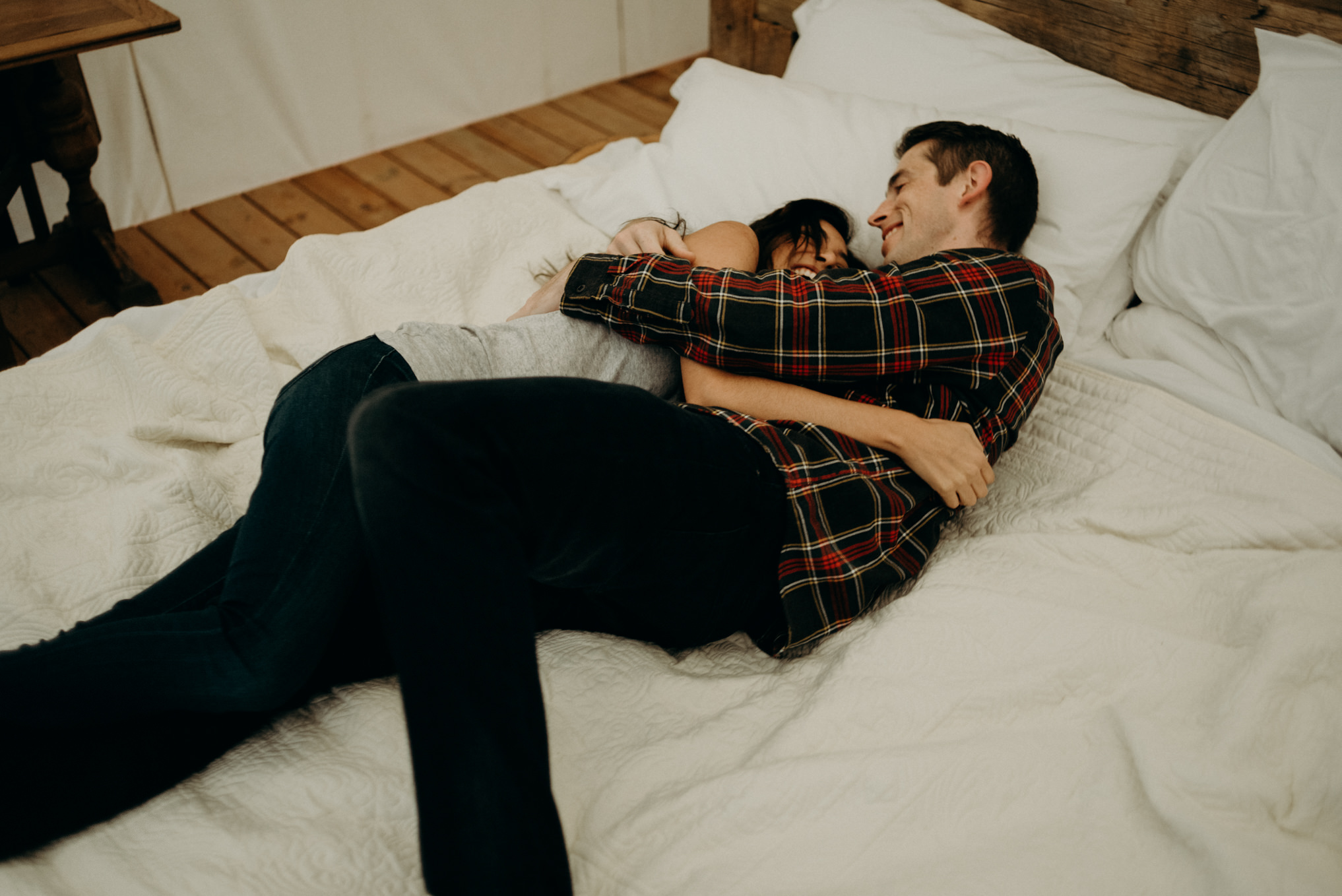 Couple cuddling on bed in glamping tent at Whispering Springs