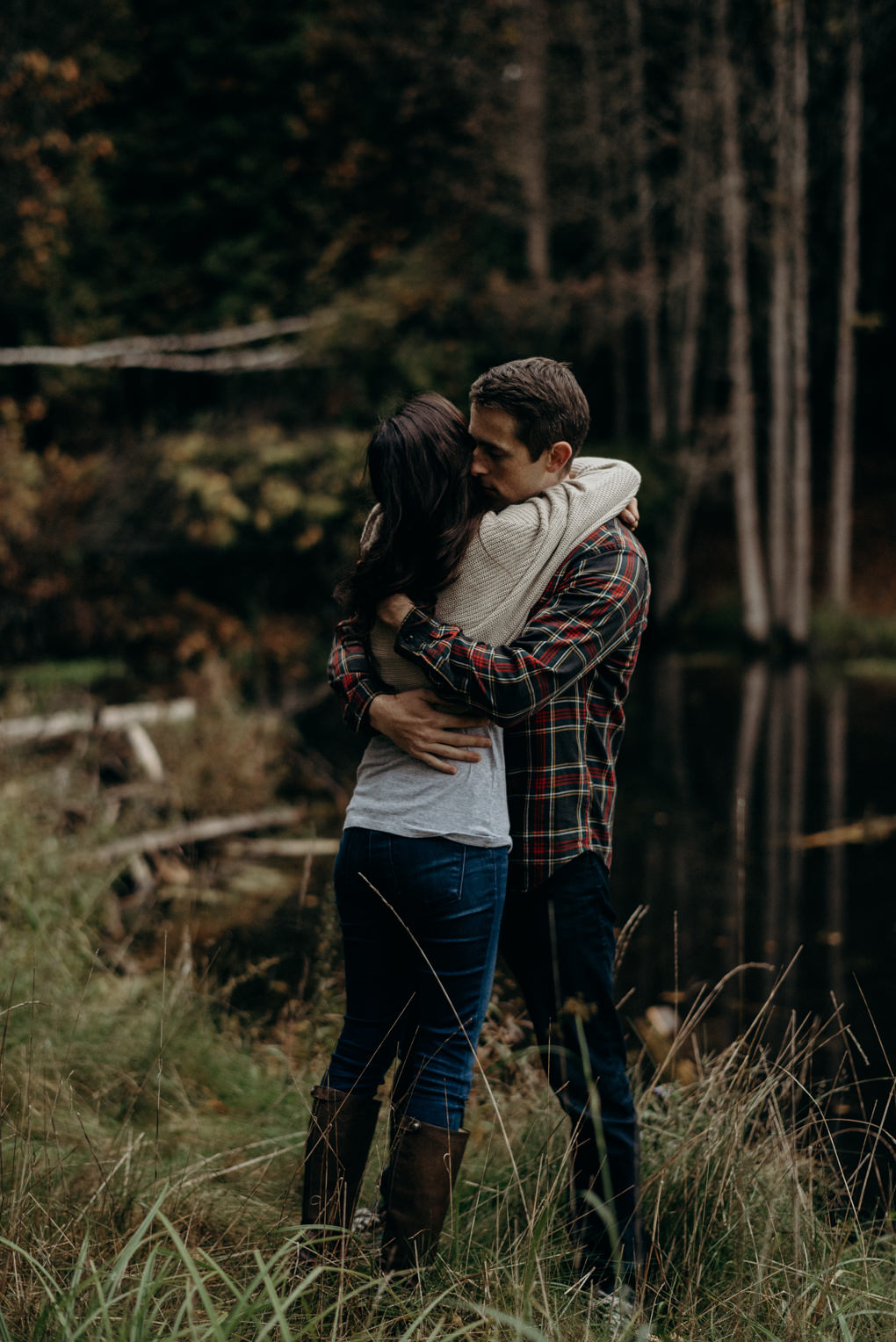 Couple standing beside pond at luxury glamping tent spot at Whispering Springs