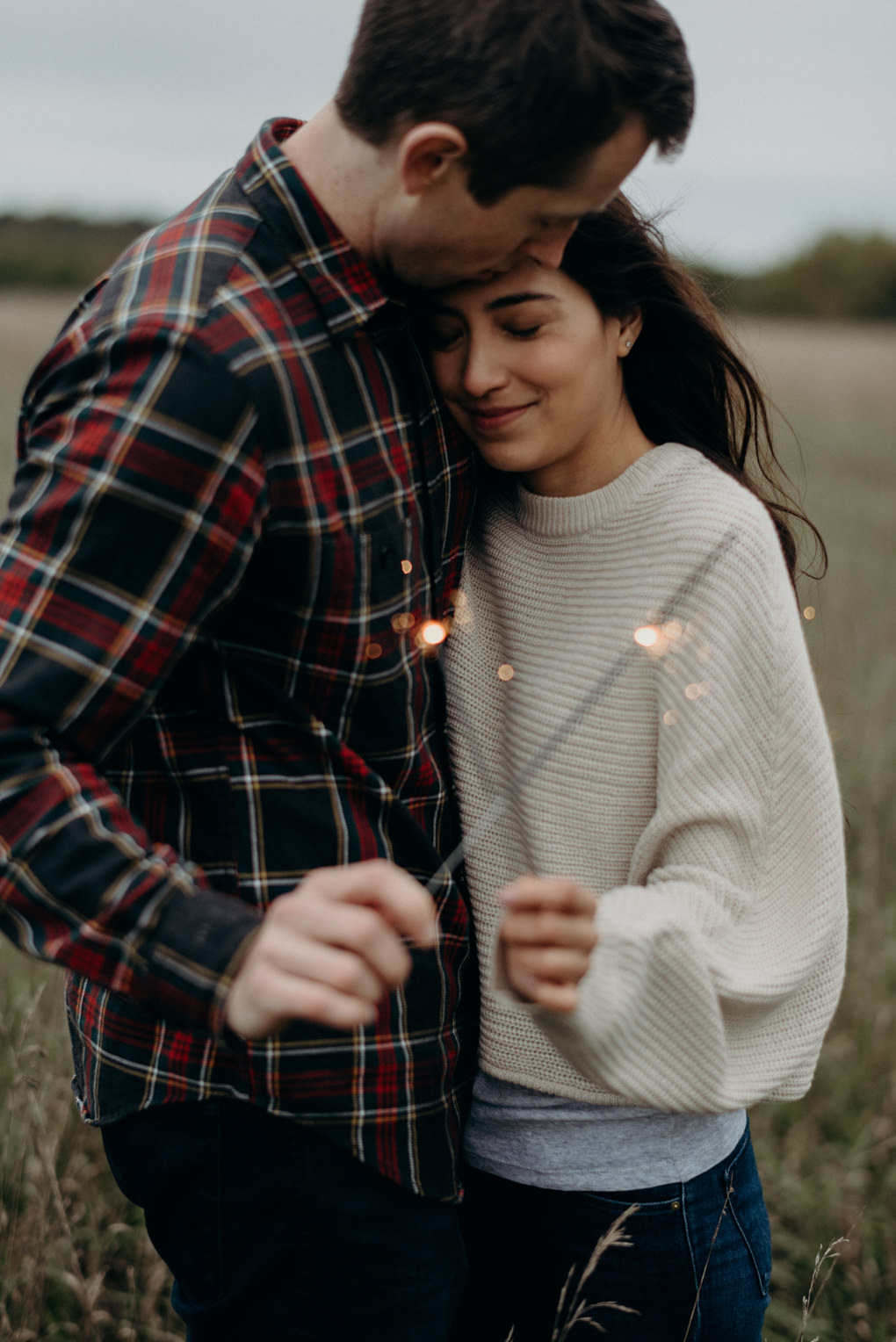 Couple laughing and holding sparklers