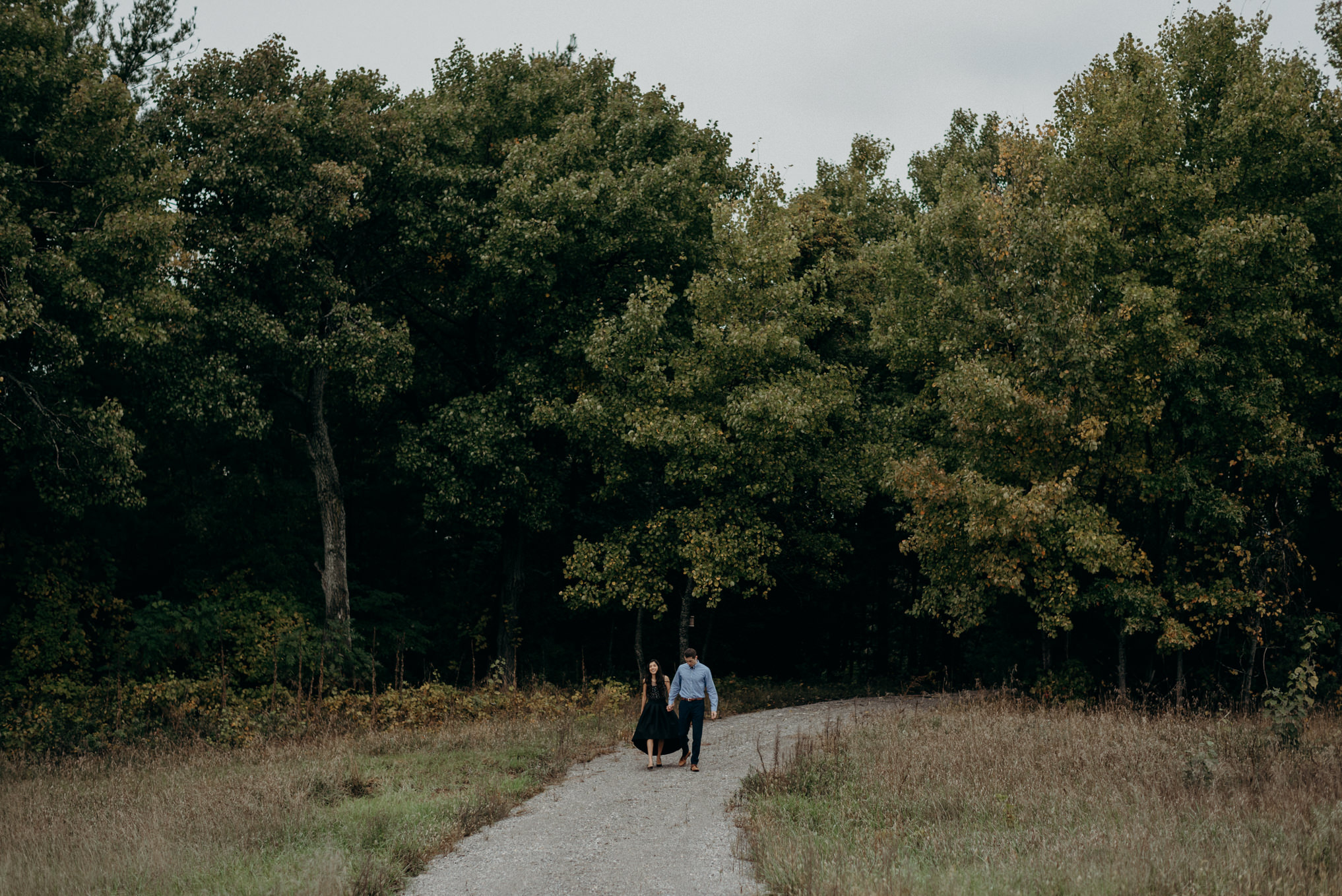 formal portrait of couple hugging outside by forest