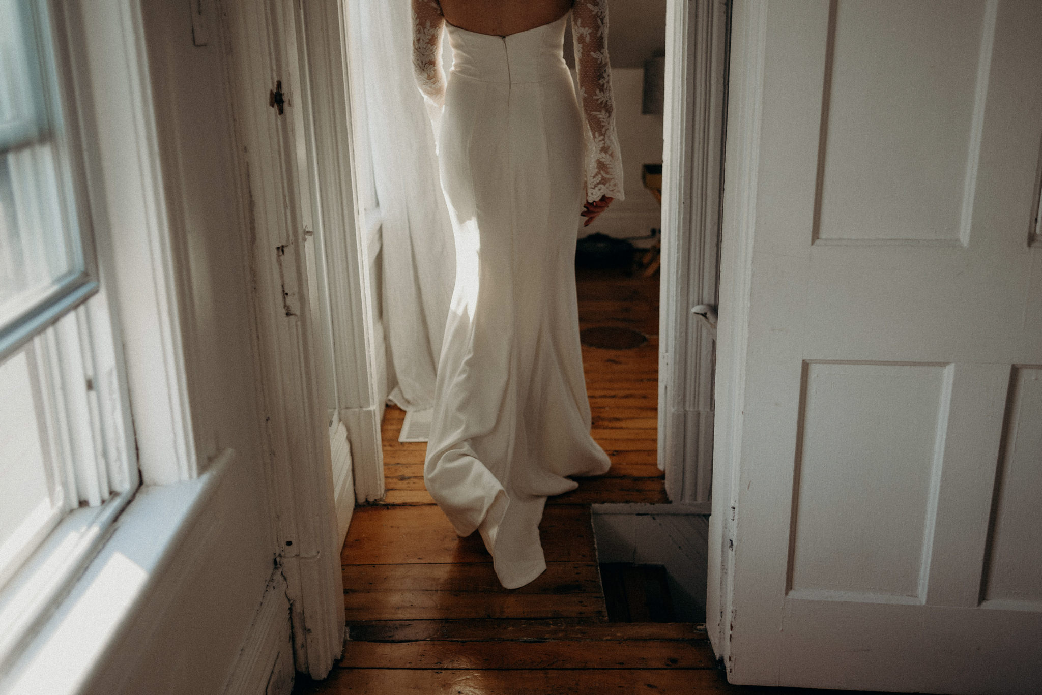 bride in wedding dress walking into bedroom