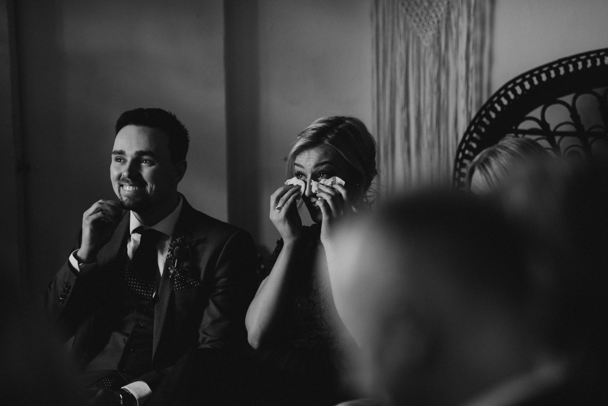 female guest crying and wiping tears during wedding ceremony