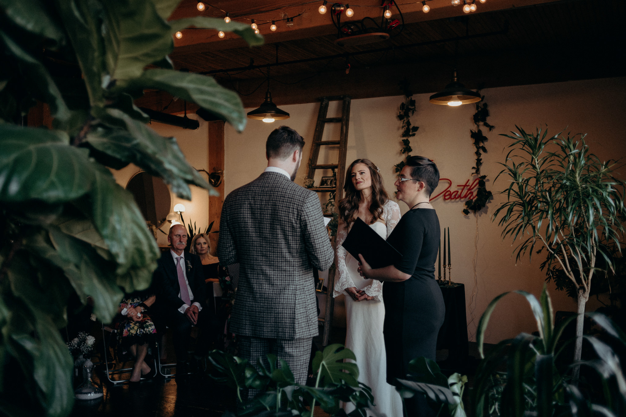 groom reading vows to bride surrounded by plants in old loft apartment, loft wedding in Toronto