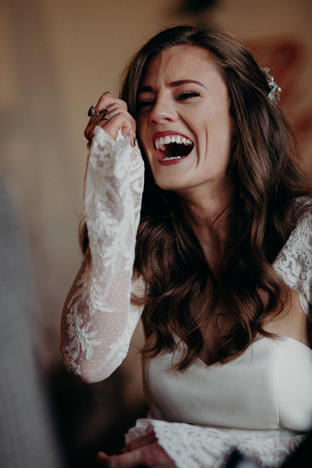 bride and groom holding hands during wedding ceremony with string lights in old loft