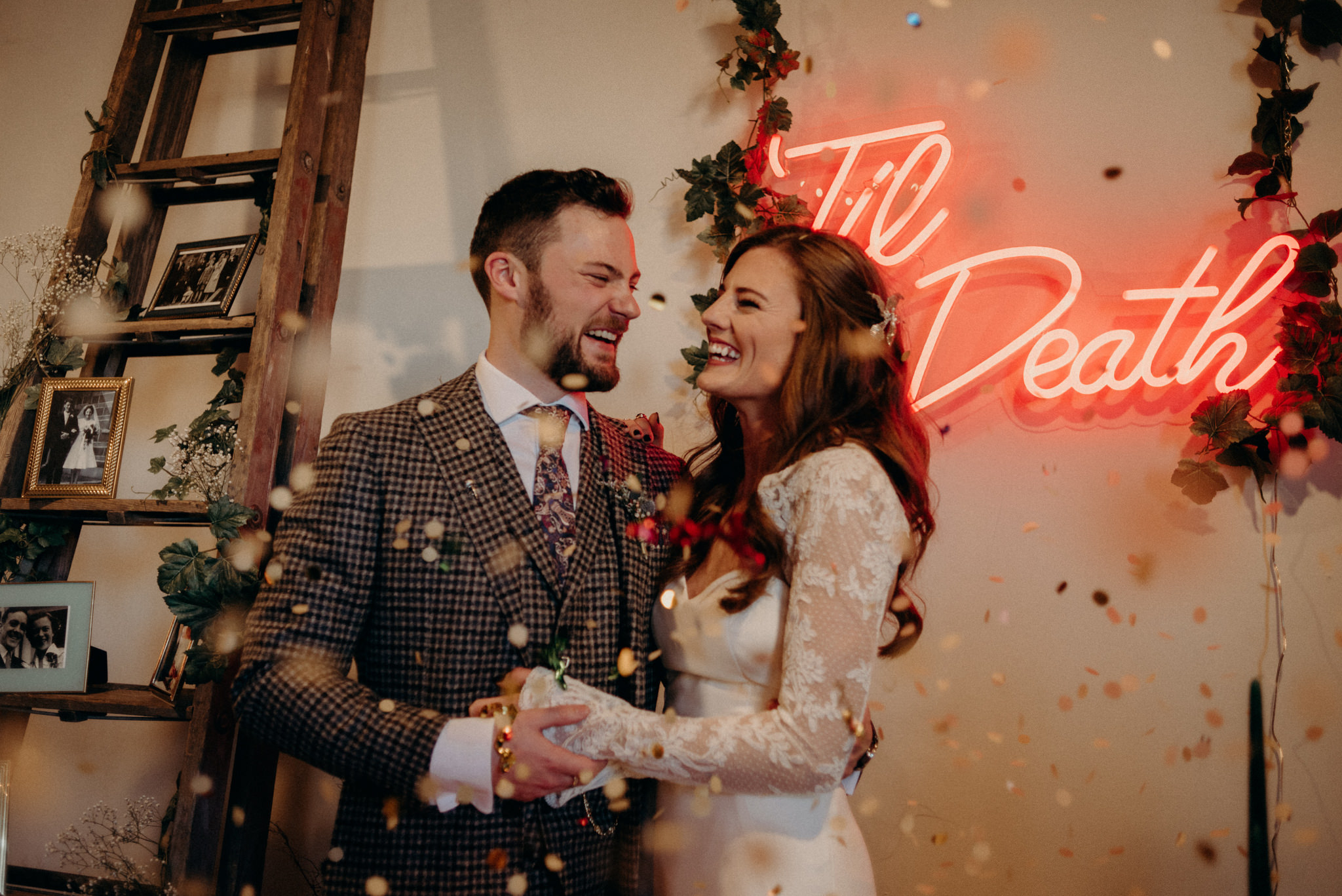 bride and groom laughing as guests toss confetti at them after the wedding ceremony in old loft in Toronto