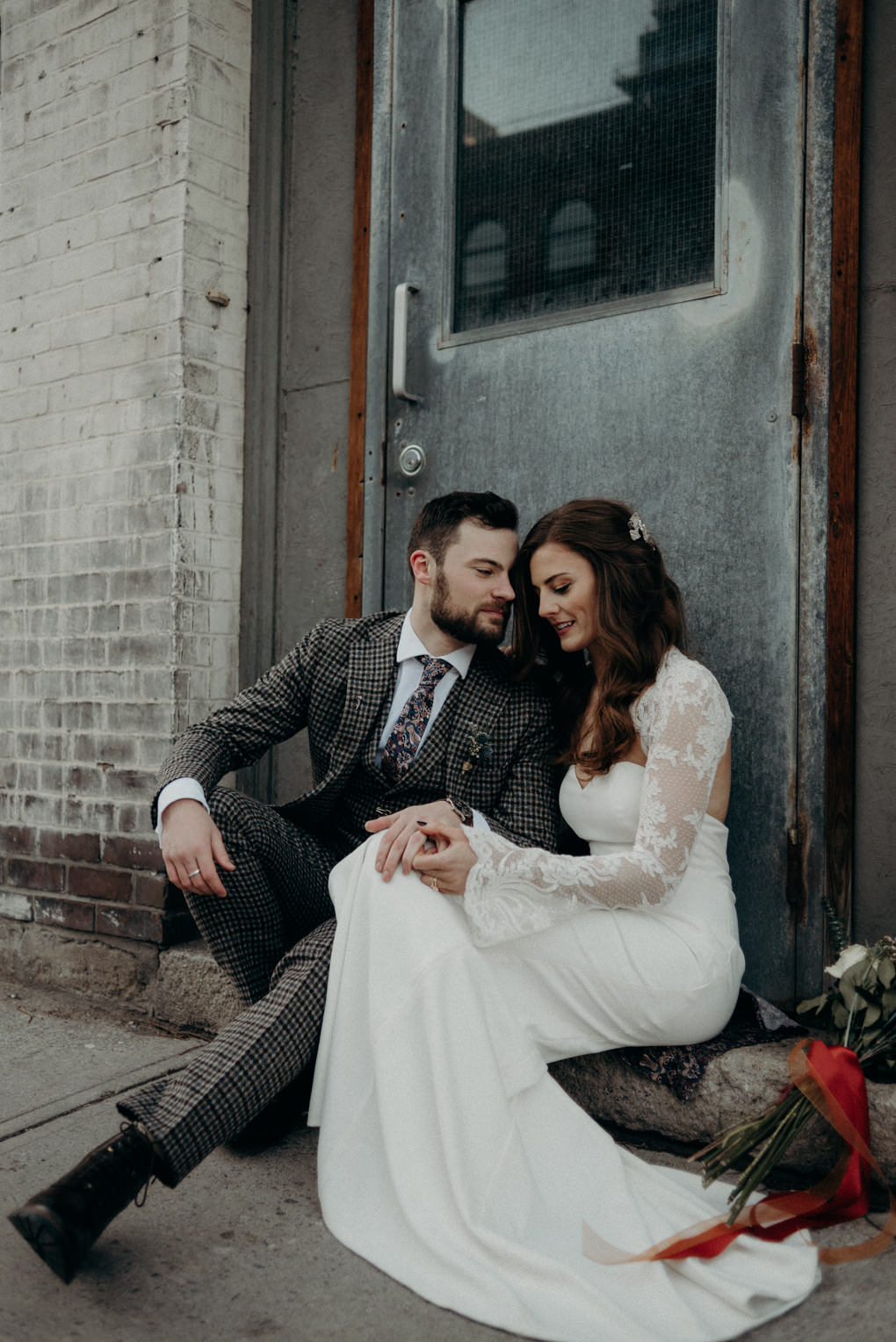 bride and groom sitting on doorstep