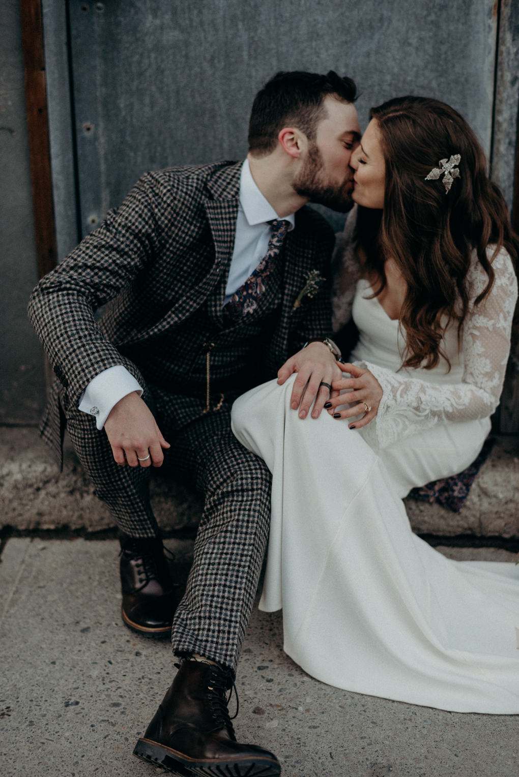 bride and groom kissing and sitting on doorstep on street