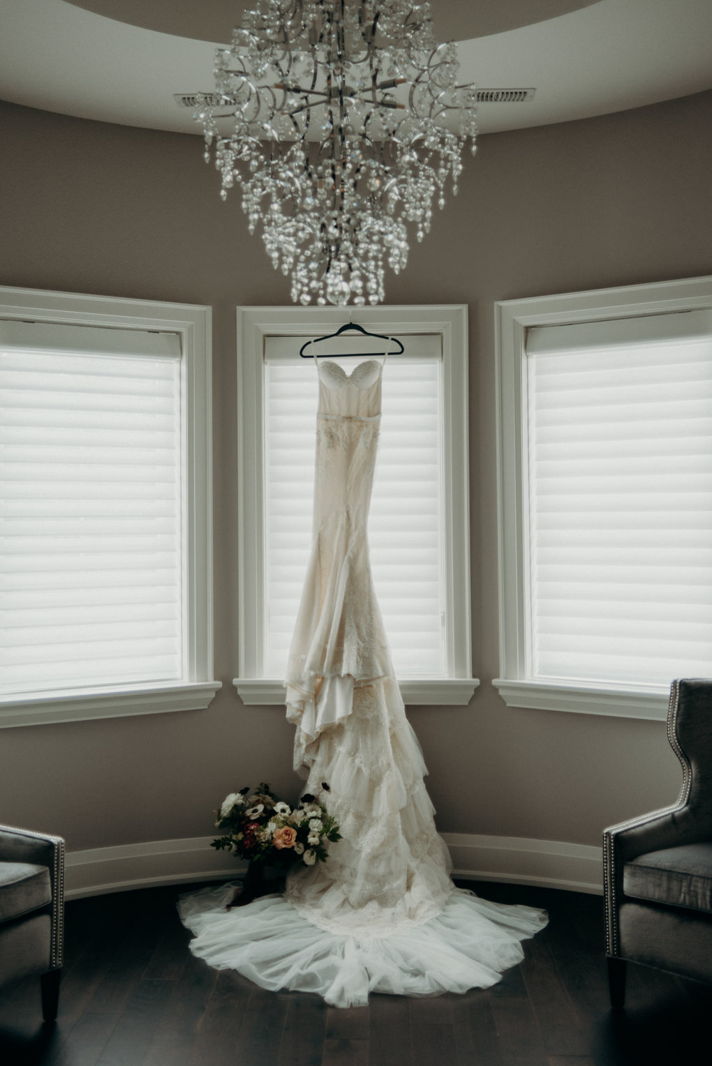 wedding dress with long train hanging in window