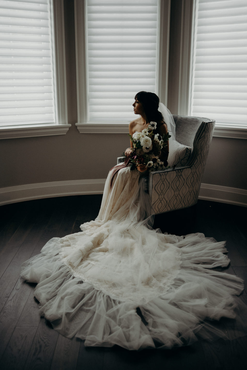 ethereal portraits of bride sitting in chair with bouquet 