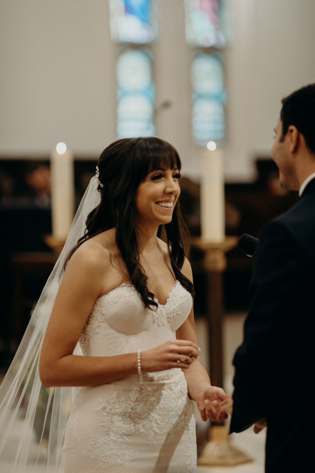 bride smiling while exchanging rings with groom