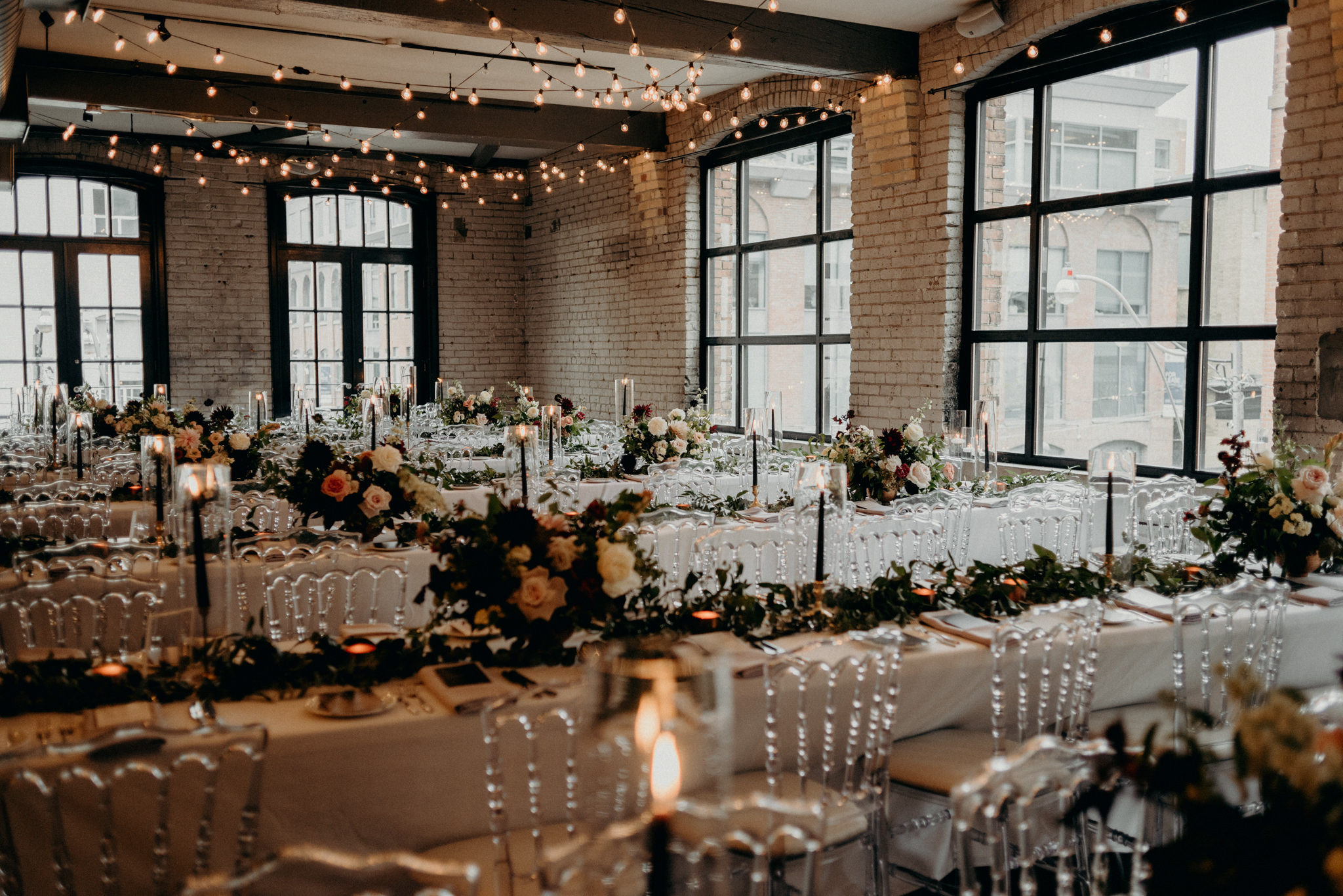 Romantic Storys Building wedding reception setup with string lights and candles on table