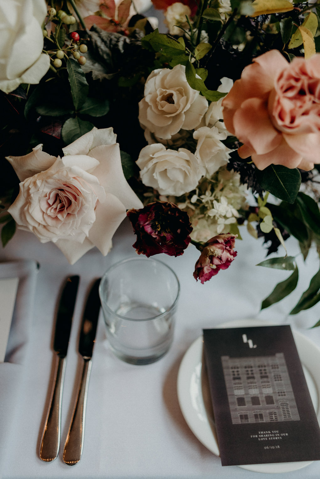 blush, coral and maroon flowers on table for wedding reception at Storys Building