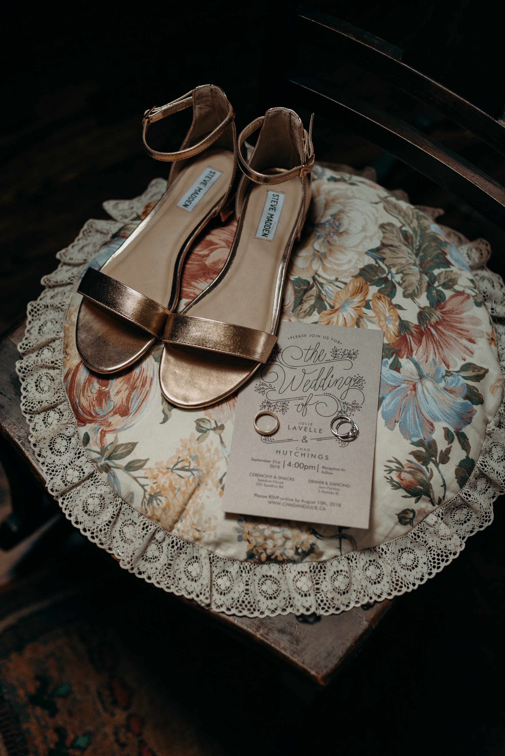 wedding shoes, invitation and rings on round floral pillow