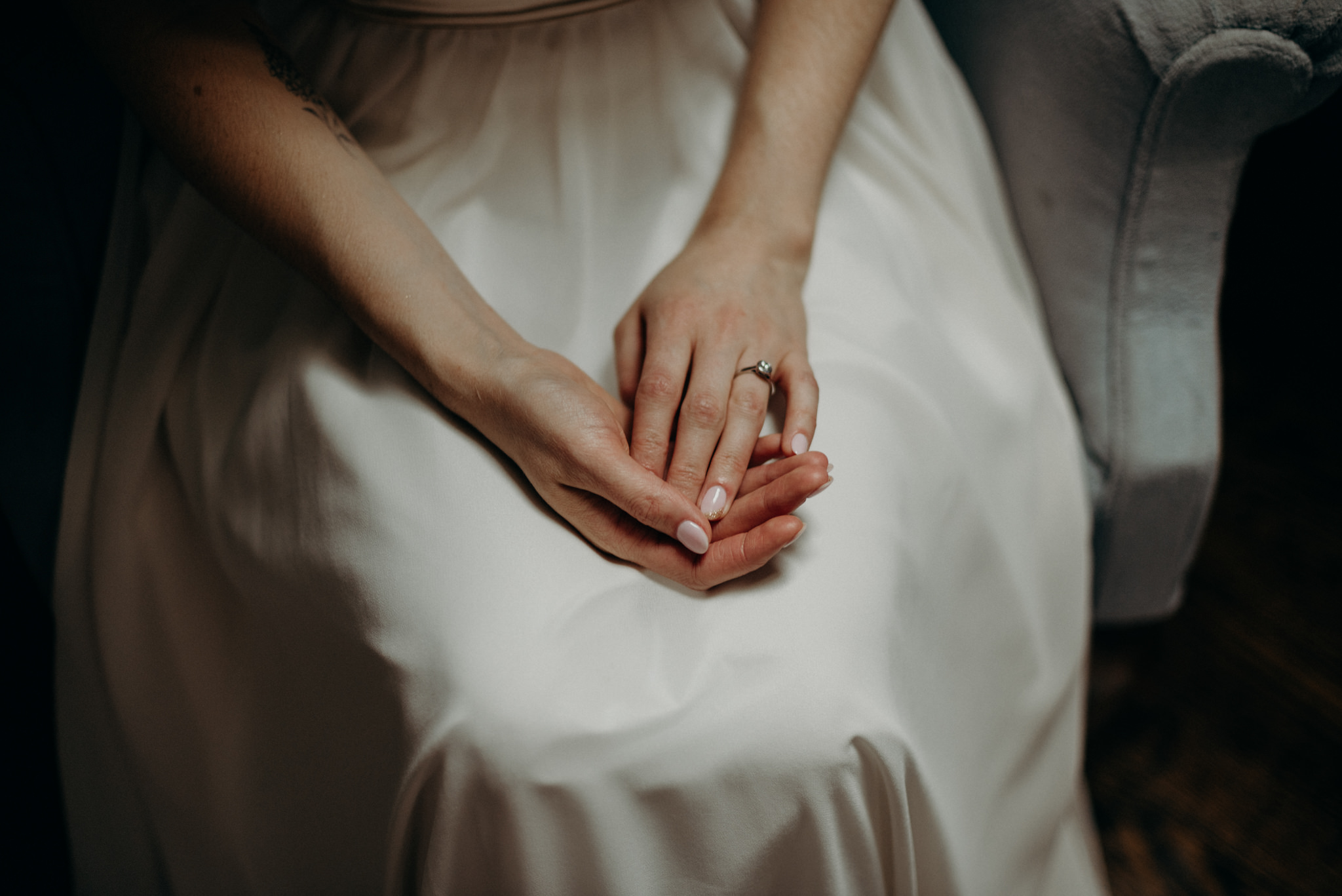 bride in dress, holding hands in lap