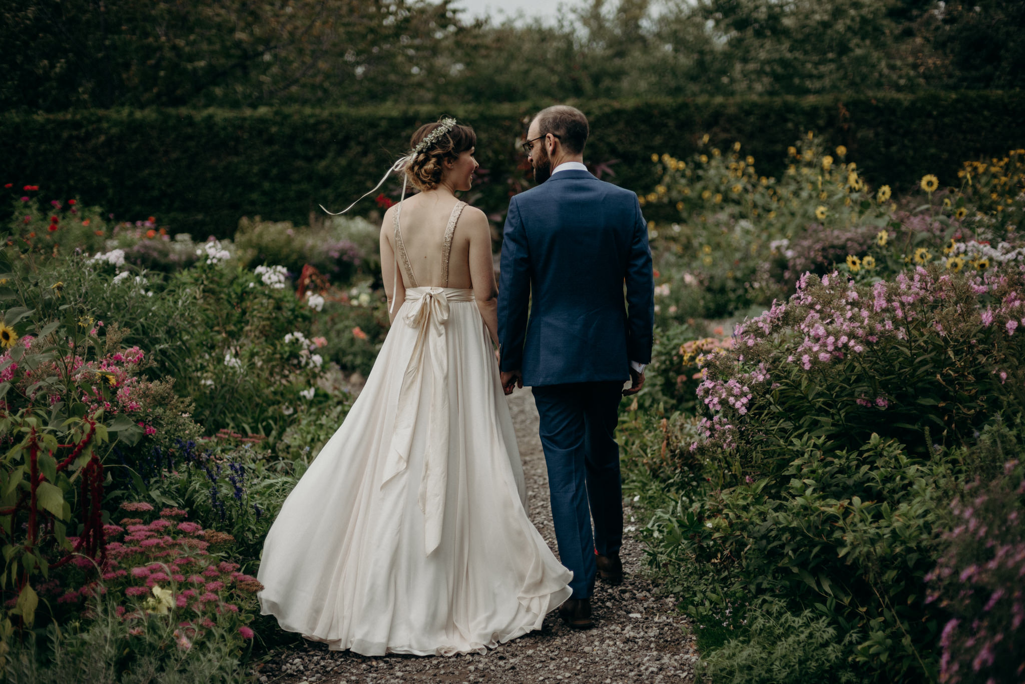 bride and groom walking in flower gardens