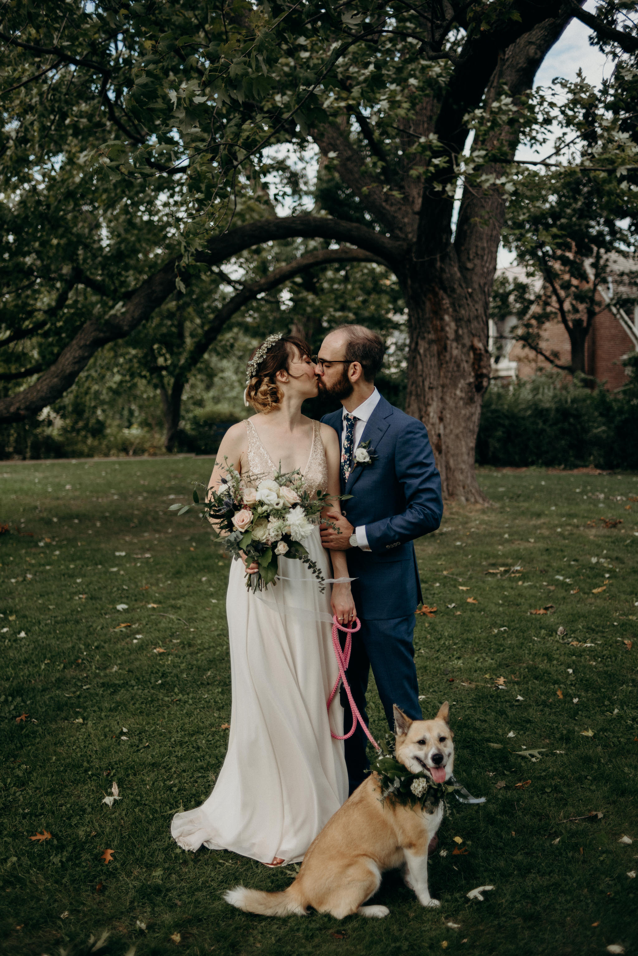 Bride and groom kissing with dog in floral crown at Spadina Museum