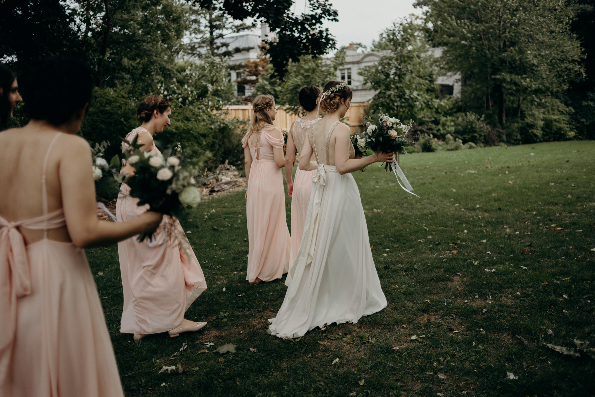 bridesmaids walking on grass at Spadina Museum