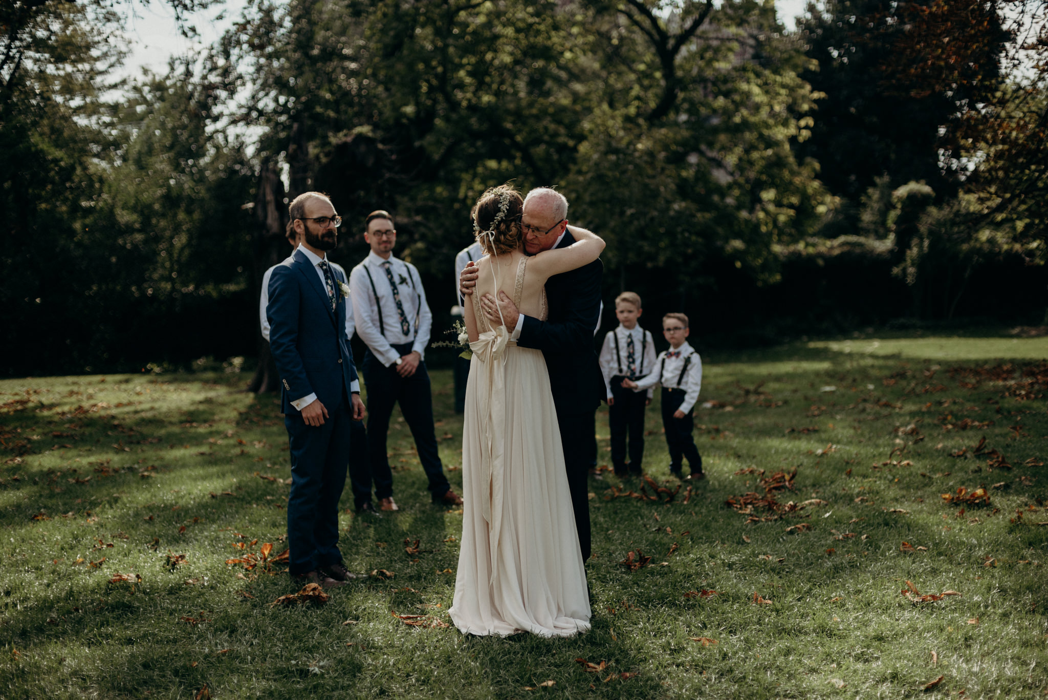 bride hugging father during wedding ceremony outside