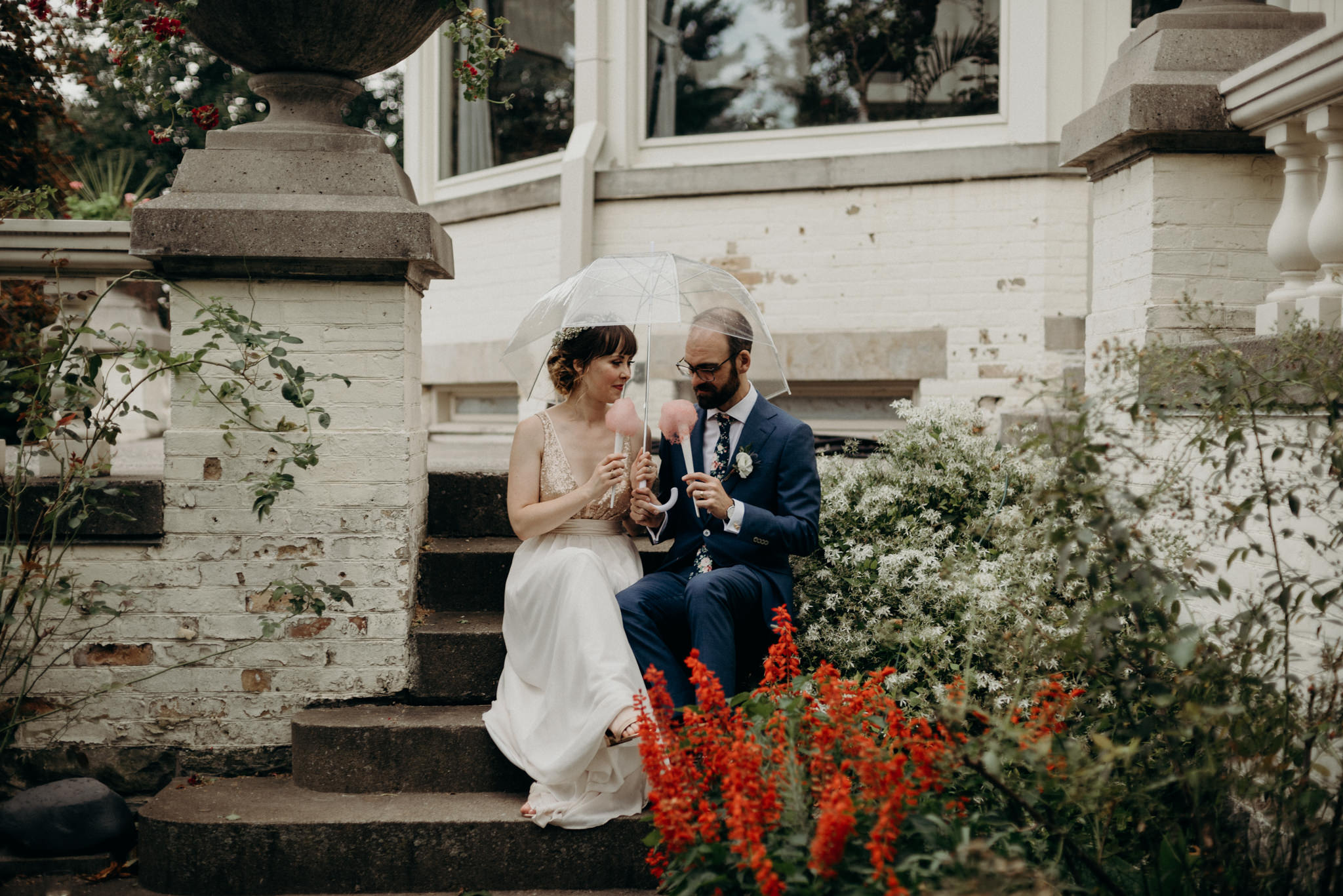 bride and groom sitting on steps of Spadina Museum eating cotton candy