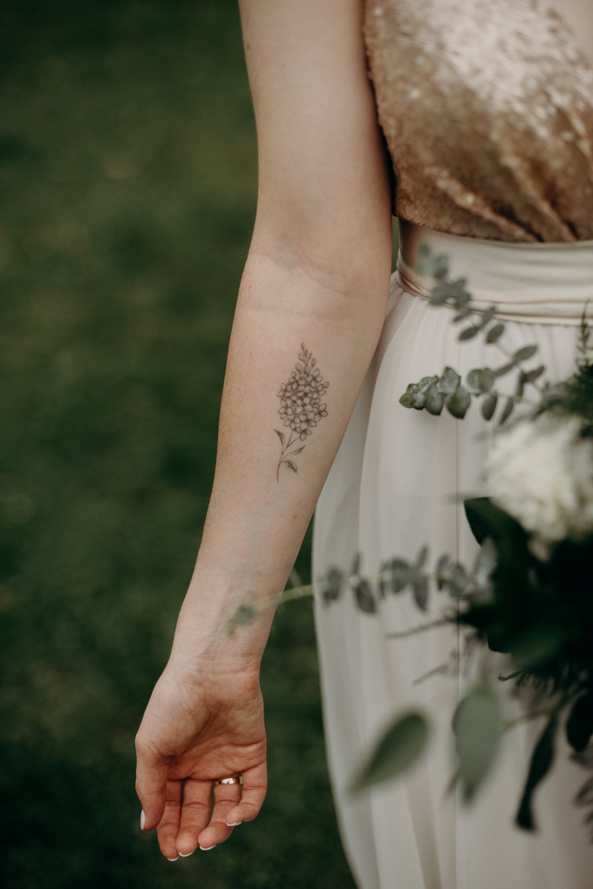 bride with floral tattoo on forearm