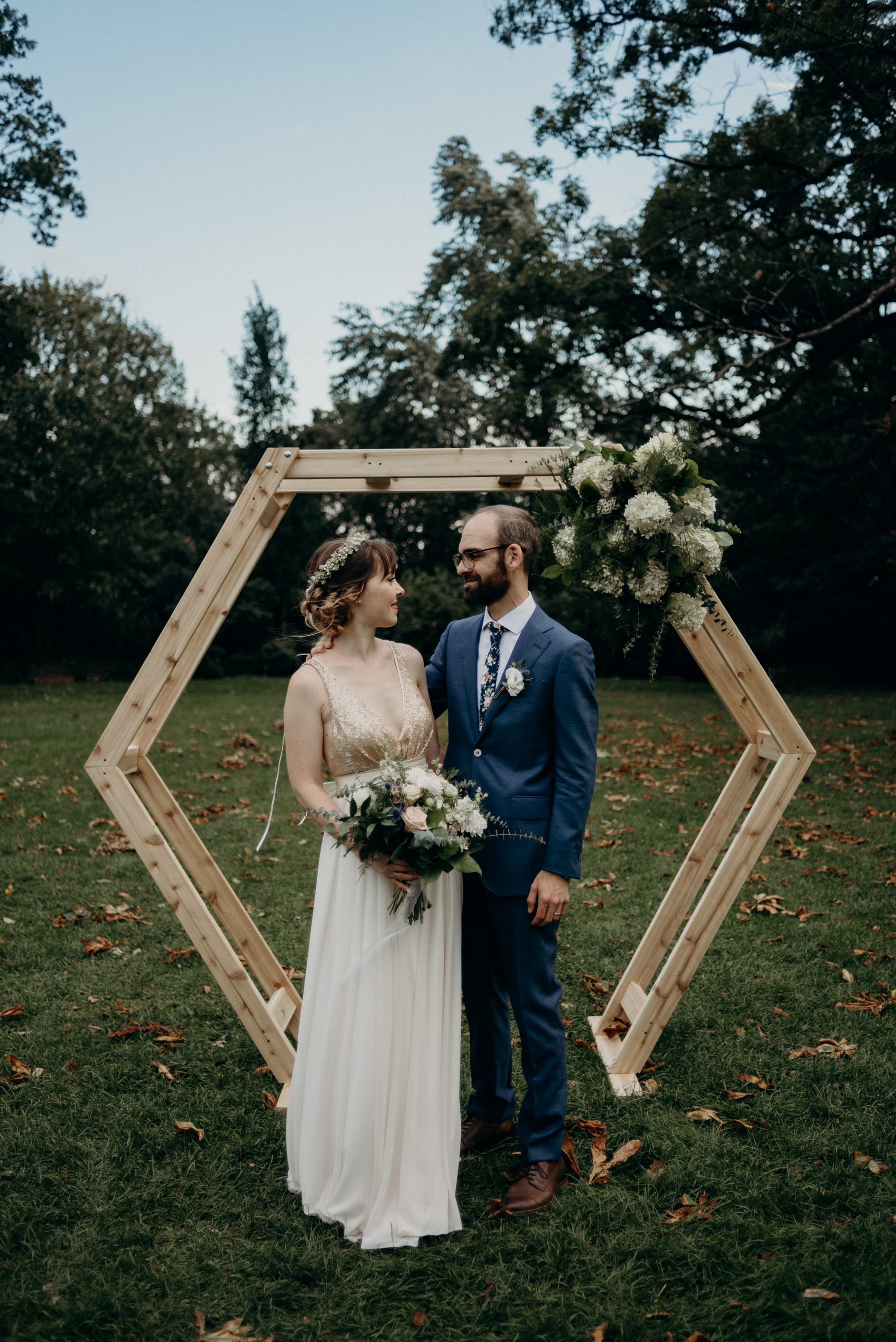 Wedding portrait in front of wood hexagon backdrop outside at Spadina Museum