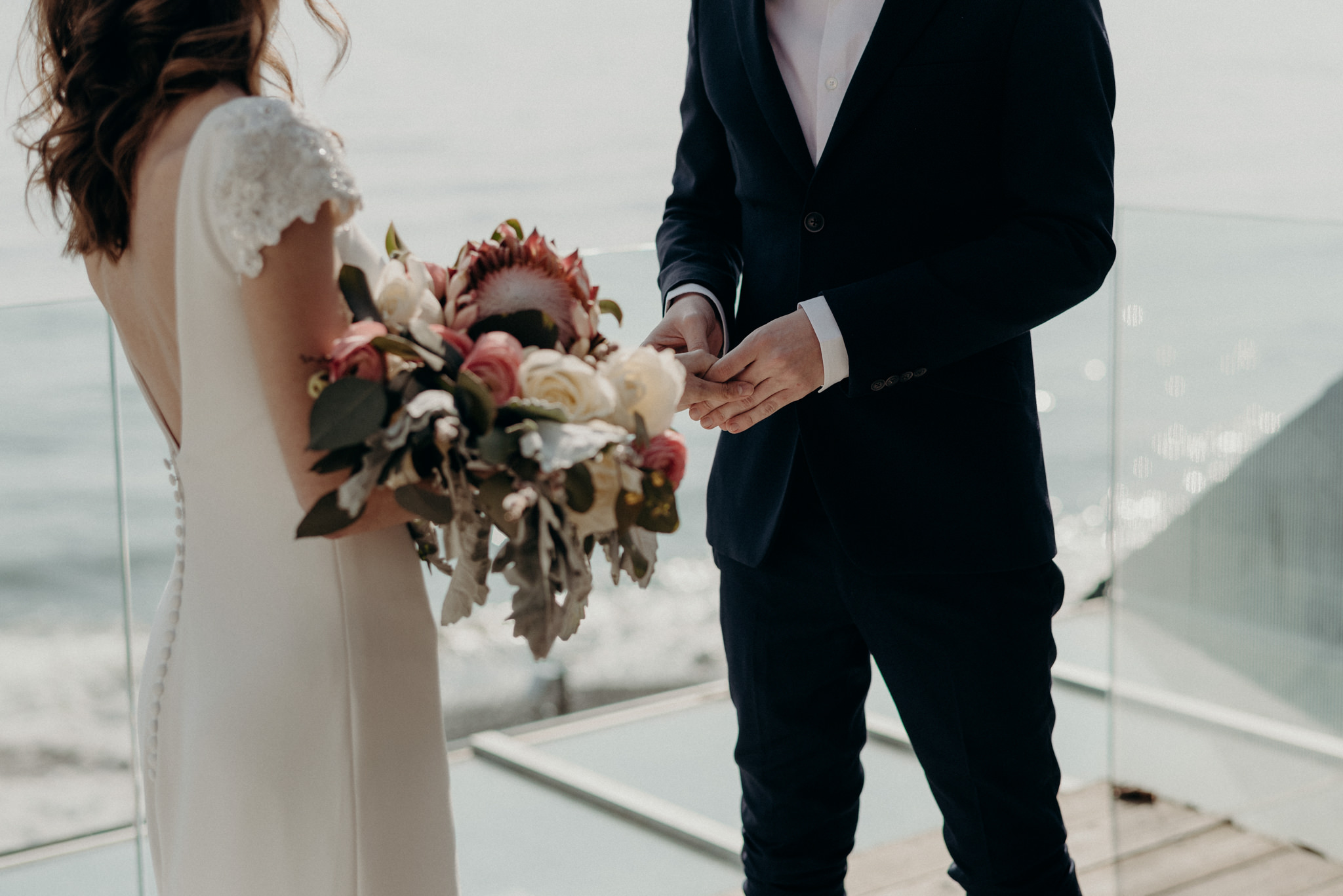 groom holding brides hand during outdoor winter wedding ceremony