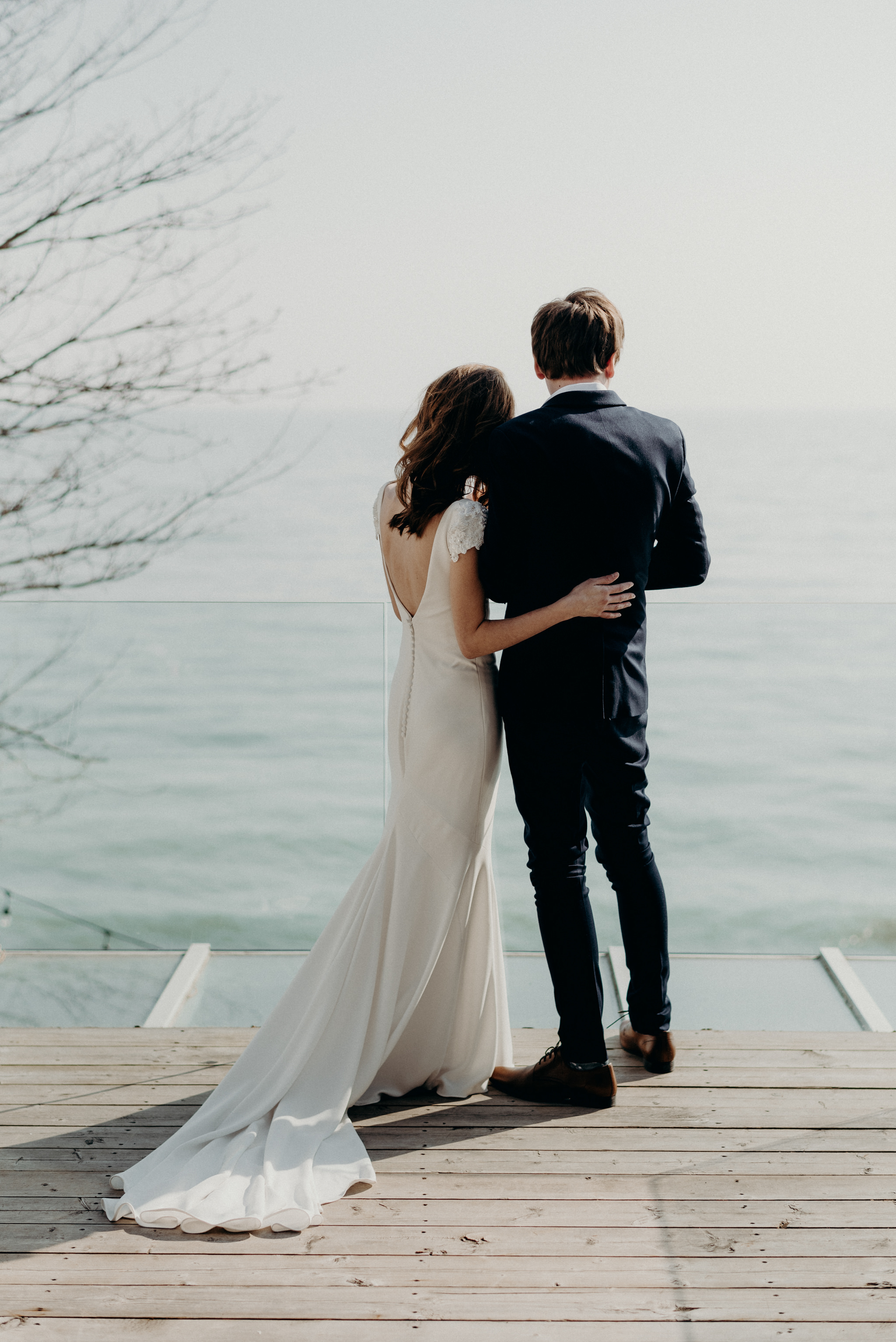 bride and groom looking out onto water from patio of owner's suite at Drake Devonshire Inn